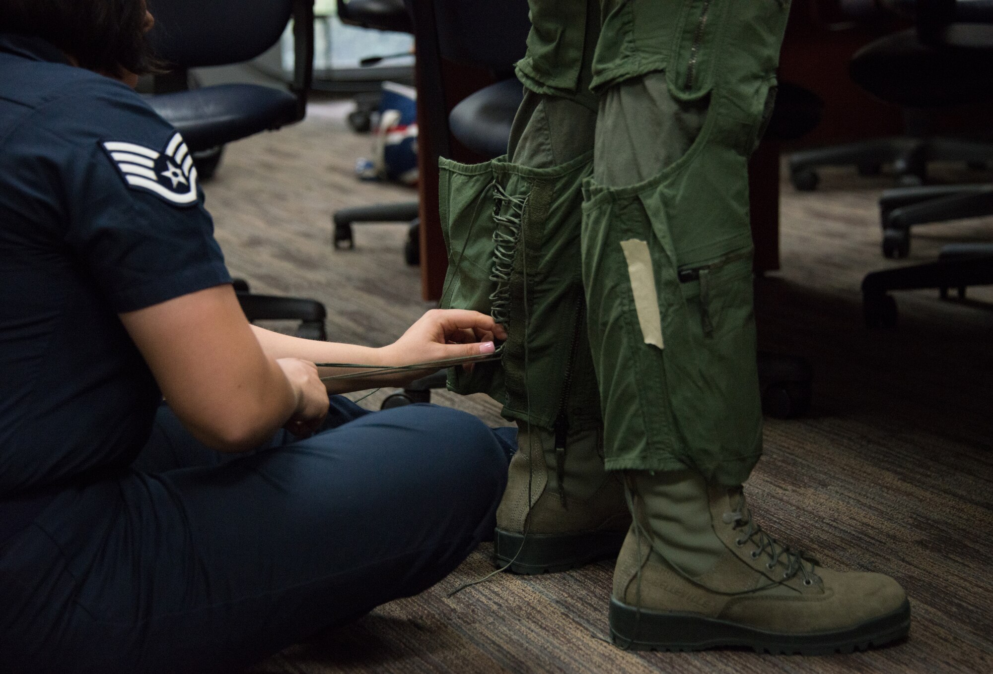 Staff Sgt. Madeline Conley, U.S. Air Force Thunderbirds aircrew flight equipment technician, secures a flight suit for Meggan Gray, WLOX anchor, March 26, 2015, at Keesler Air Force Base, Miss.  The fitting for Gray was in preparation for a media flight with the U.S. Air Force Thunderbirds March 27.  The Thunderbirds are at Keesler for the 2015 Keesler Air Show/Open House to be held March 28-29. (U.S. Air Force photo by Marie Floyd)