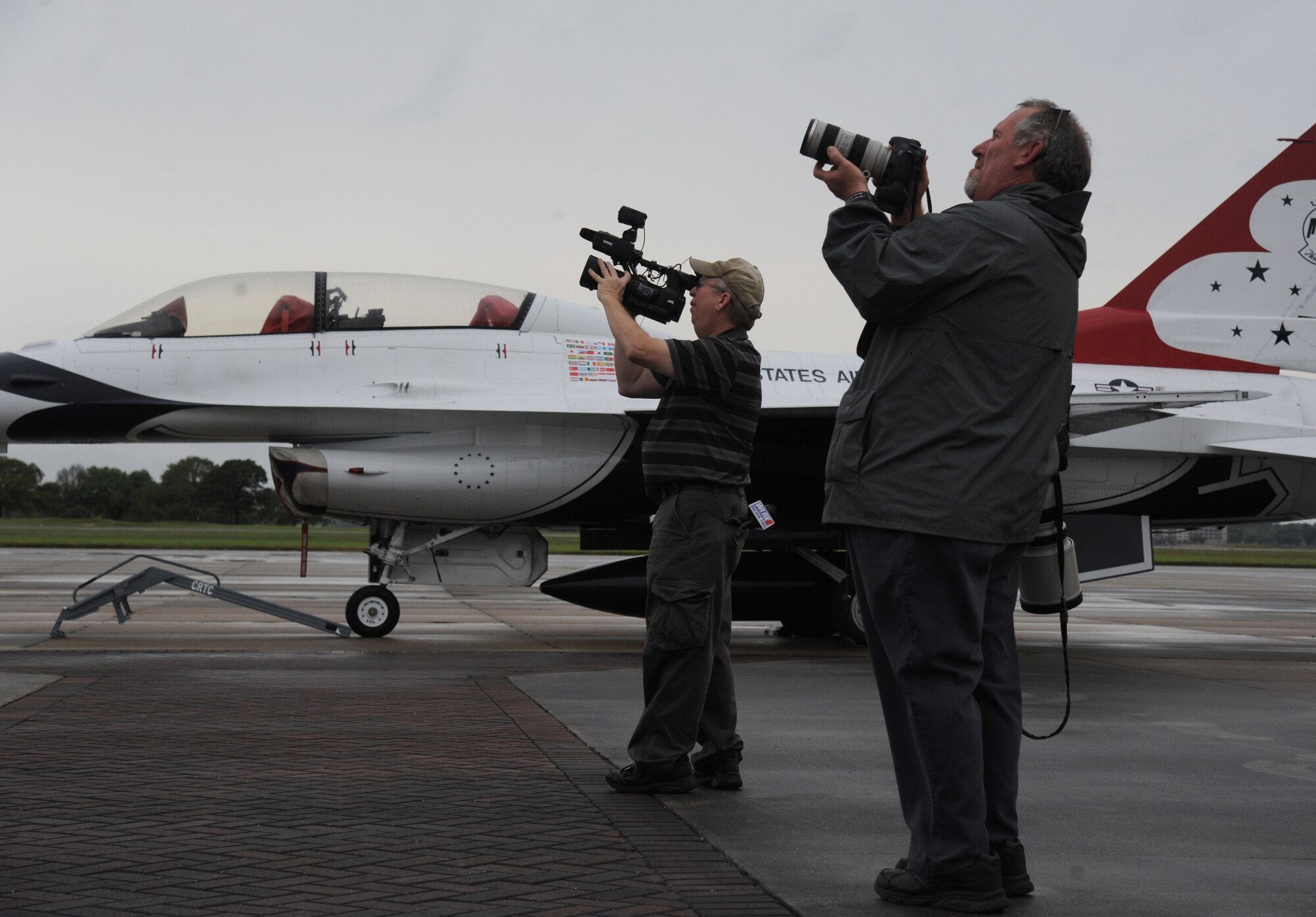 Rodney Billingsby, WLOX camera operator, and Tim Isbell, Sun Herald photographer, capture images of the U.S. Air Force Thunderbirds March 26, 2015, as they circle Keesler Air Force Base, Miss. The Thunderbirds will be the performing in the 2015 Keesler Air Show/Open House to be held March 28-29.  It is their first air show appearance at Keesler since 2009.  (U.S. Air Force photo by Kemberly Groue)
