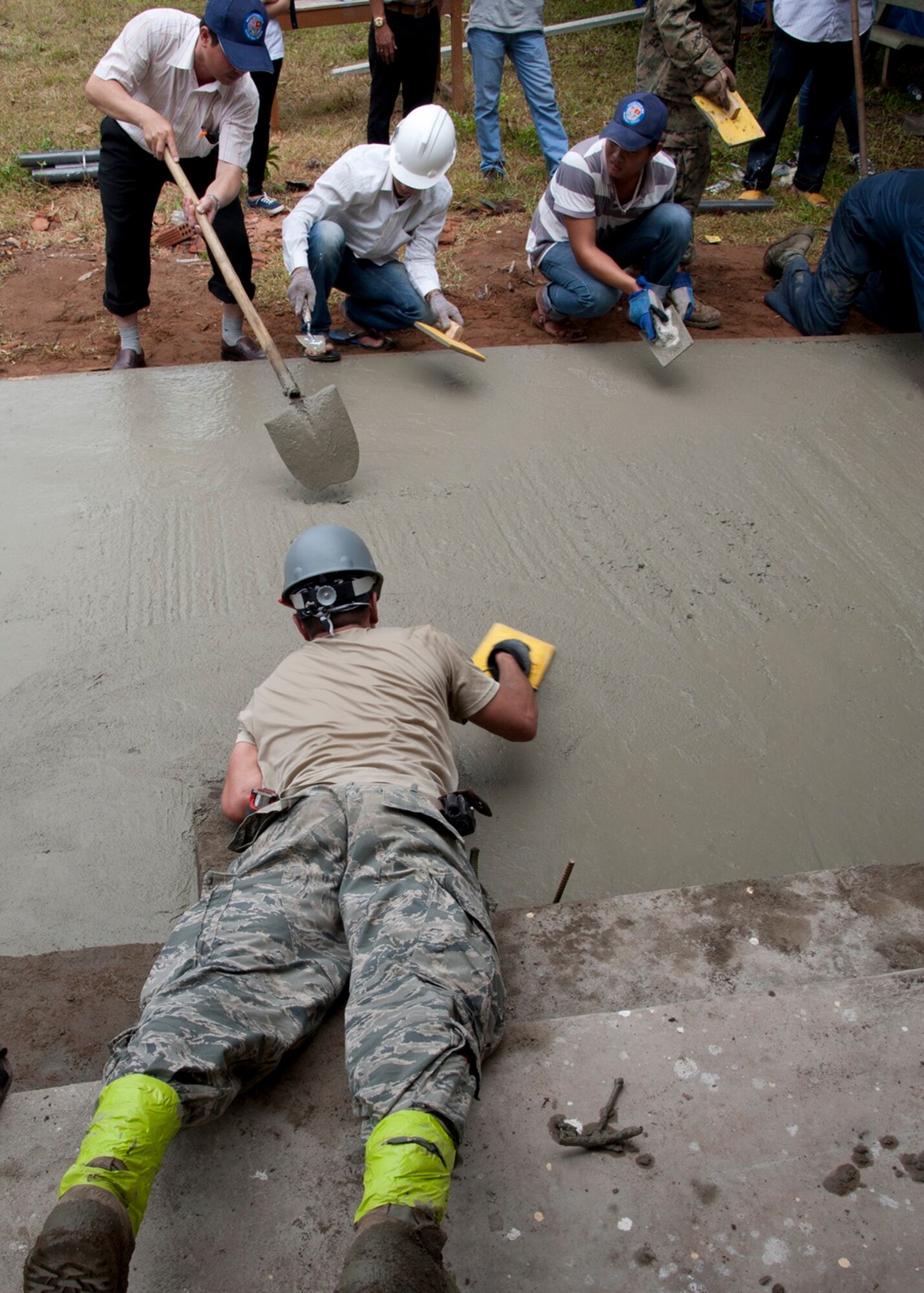 U.S. Air Force and Vietnam People's Army members smooth out concrete at Binh Thanh Dong primary school, Quang Ngai Province, Vietnam, during an engineering project, March 25, 2015. Operation Pacific Angel 15-3 is a multilateral humanitarian assistance civil military operation, which improves military-to-military partnerships in the Pacific while also providing medical health outreach, civic engineering projects and subject matter exchanges among partner forces. (U.S. Air Force photo by Staff Sgt. Tong Duong/ Released)