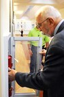 Dr. Paul M Allen inspects a fire extinguisher during an Accreditation Association of Ambulatory Health Care inspection, Mar. 24, 2015, at Malmstrom Air Force Base, Mont. The AAAHC survey also helps to identify areas within the hospital that could possibly improve and enhance the quality of health care provided.  (U.S. Air Force photo/Chris Willis)