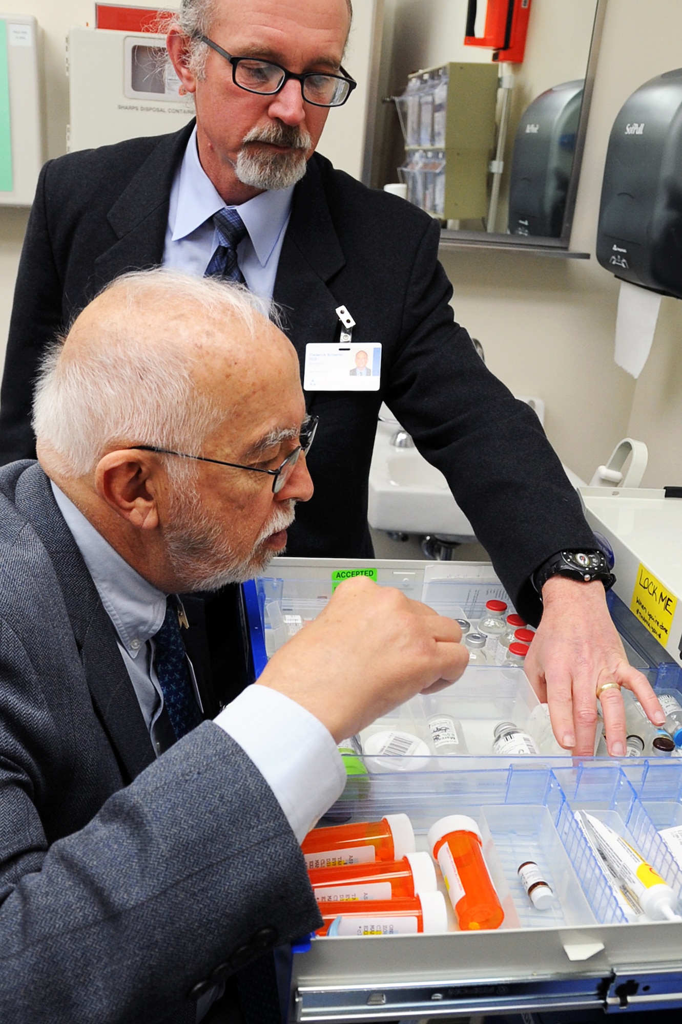 Col. (Ret) Frederick Schaefer, (back), and Dr. Paul Allen, inspect a medical cabinet during an Accreditation Association of Ambulatory Health Care inspection, Mar. 24, 2015, at Malmstrom Air Force Base, Mont.  The AAAHC three-day inspection occurs every three years and covers virtually every aspect of the hospital system, from patient treatment to infectious disease control.  (U.S. Air Force photo/Chris Willis)