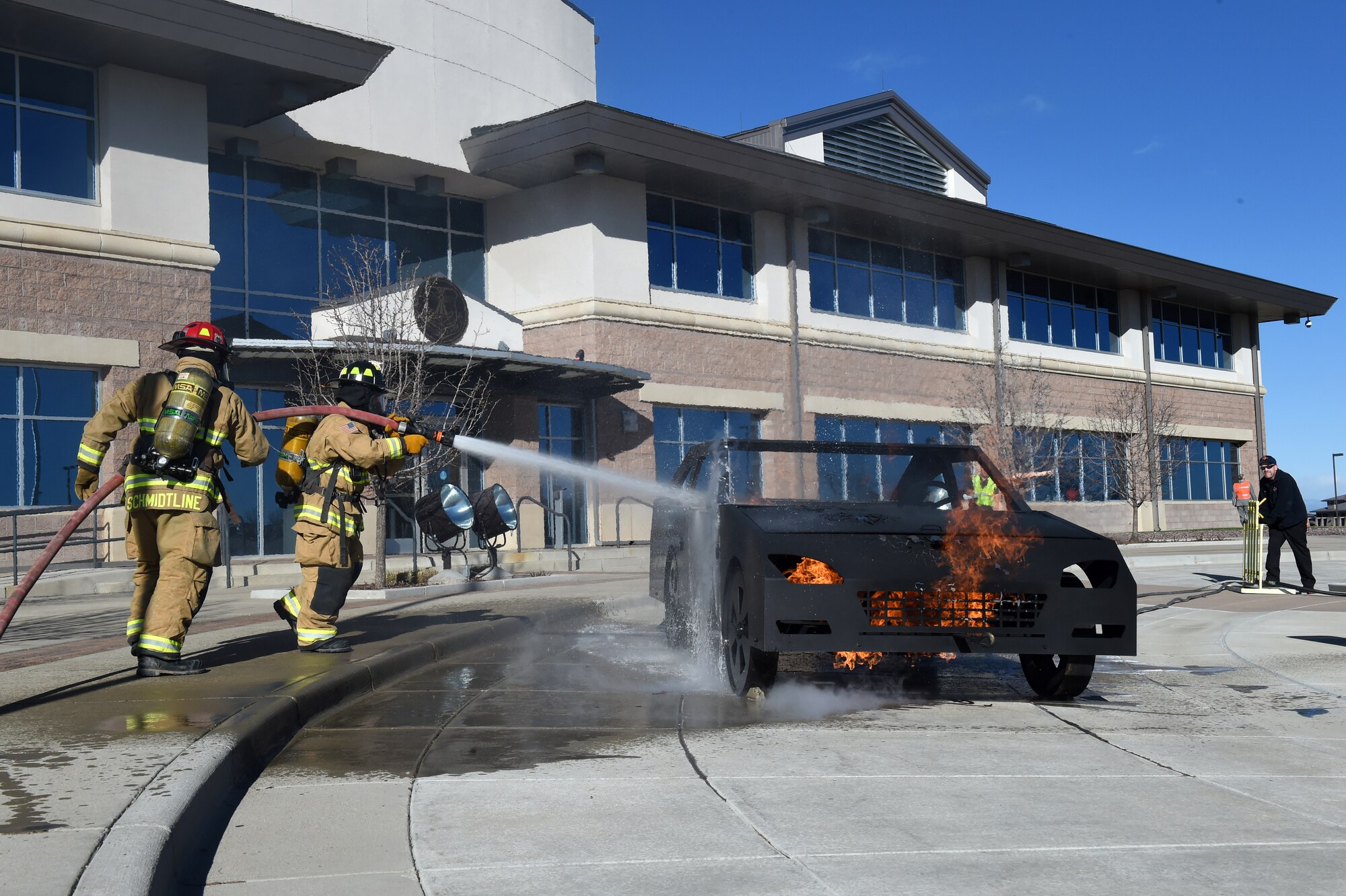 The Buckley AFB fire department puts out the fire from a simulated car explosion during the Panther Lighting exercise March 25, 2015, on Buckley Air Force Base, Colo. Panther Lightning is Buckley AFB’s version of the Strategic Command exercise, Global Lightning, which is an Air Force-wide exercise that focuses on all combatant commands and their missions. (U.S. Air Force photo by Airman 1st Class Emily E. Amyotte/Released)