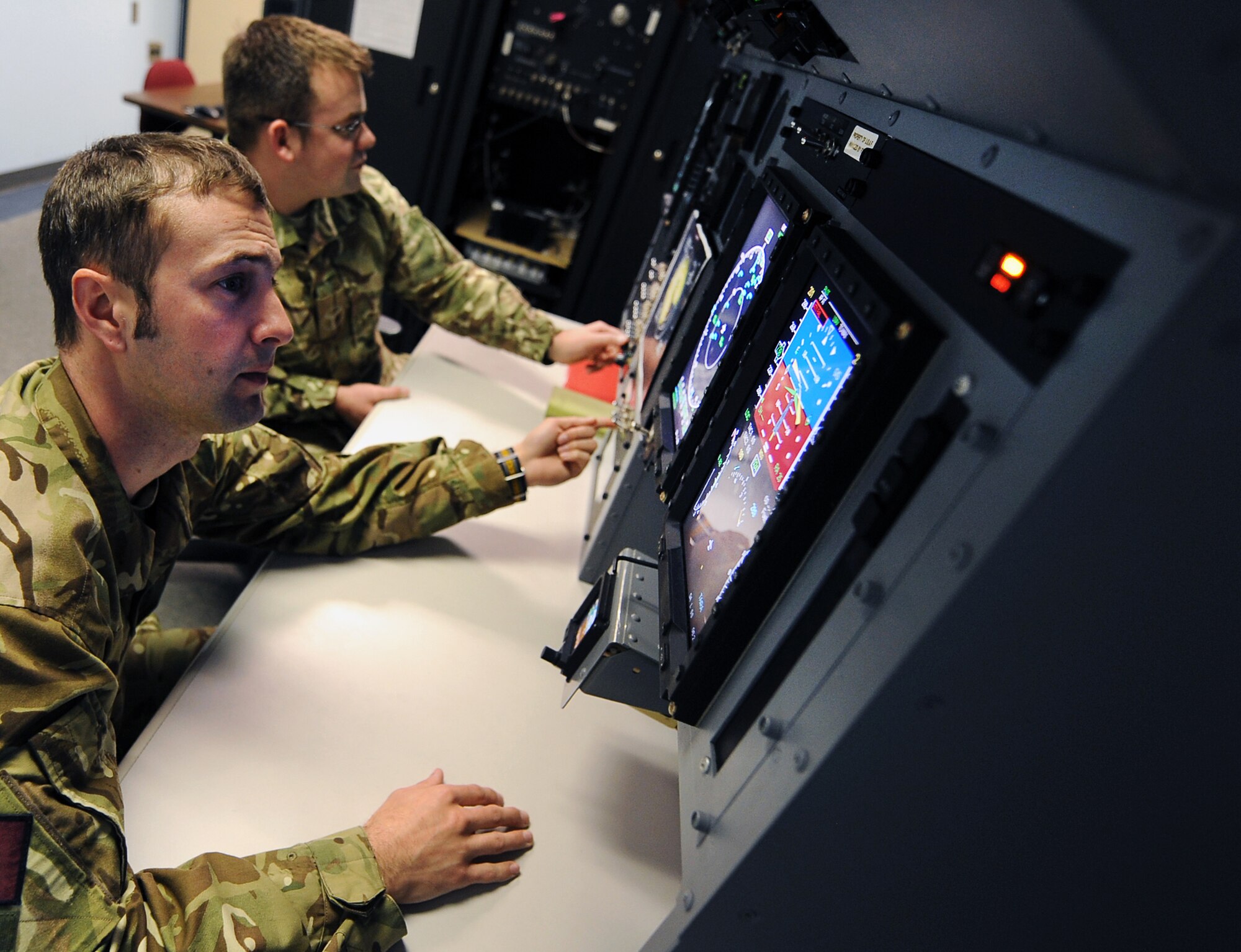 Corporal Lee Taylor (front) and Senior Aircraftsman Technical Stuart Preston (back,) from 51 Squadron, Royal Air Force Waddington, United Kingdom, practice avionics on the Rivet Glass Maintenance Trainer March 20 at Offutt Air Force Base, Nebraska. The pair will spend three months training with the 373rd Training Squadron, Detachment 11, learning RC-135 Rivet Joint avionics. (U.S. Air Force photo by Josh Plueger/Released)