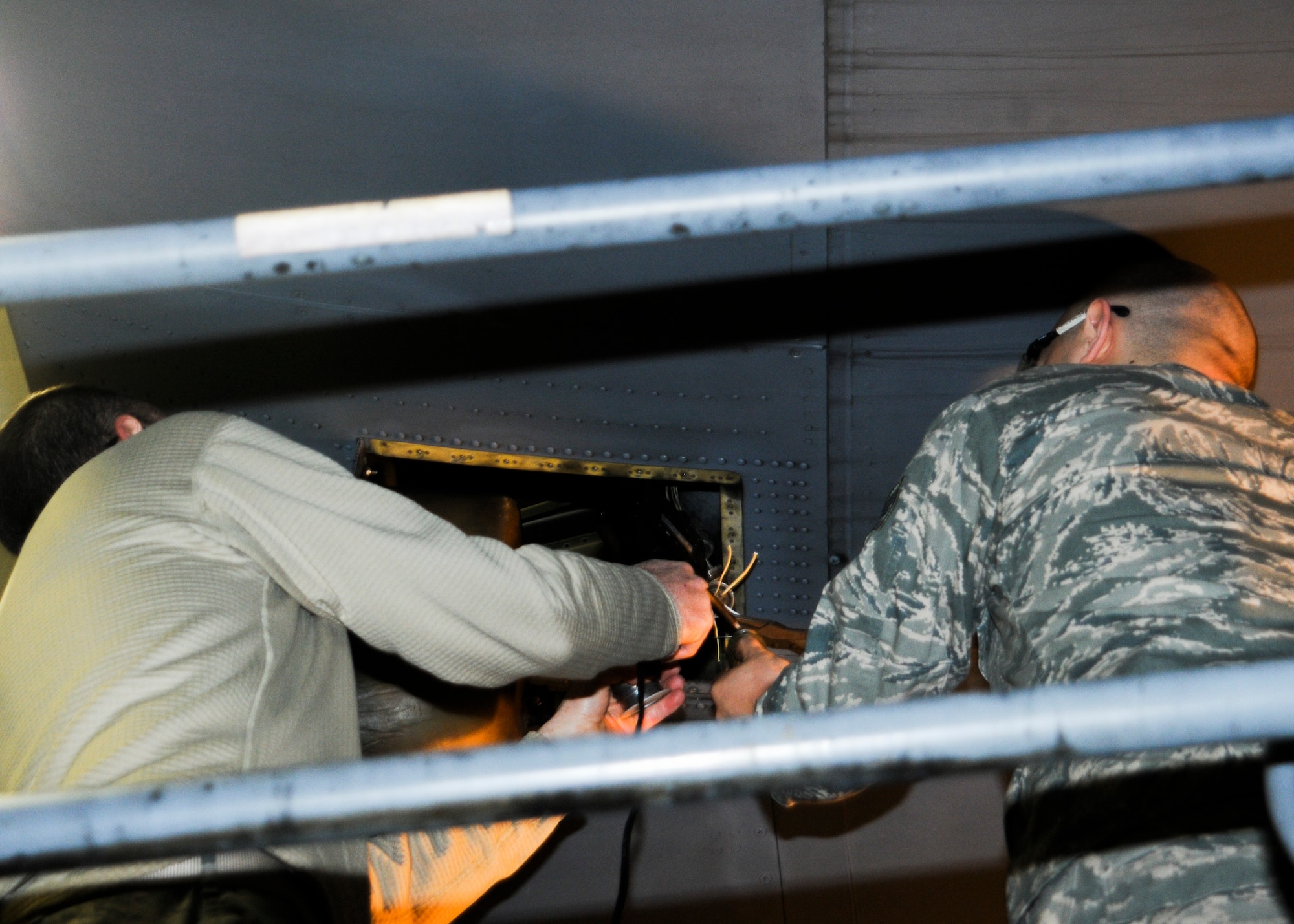 YOUNGSTOWN AIR RESERVE STATION, Ohio- Master Sgt.  Jim Buist and Staff Sgt. Joseph Bosak,   Electrical and Environmental Systems technicians assigned to the 910th Aircraft Maintenance Squadron, solder a cannon plug for a right landing light on a C-130 Hercules aircraft here, March 7, 2015. (U.S. Air Force Photo/Tech. Sgt. Rick Lisum)