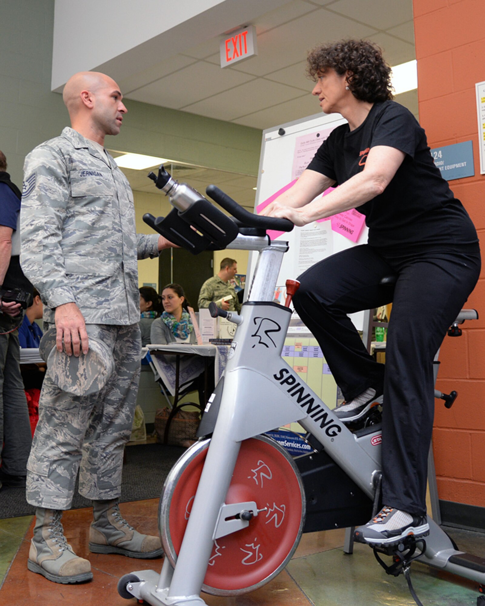 Sheryl Walsh, Fitness and Sports Center spinning instructor, explains proper technique to Tech. Sgt. Jason Jernigan, Patriot Honor Guard NCO in charge, at the Health and Fitness Expo at the Fitness and Sports Center, March 25. The base fitness center offers indoor Spinning classes each Tuesday and Thursday morning from 5:45 to 6:30 a.m. (U.S. Air Force photo by Linda LaBonte Britt)