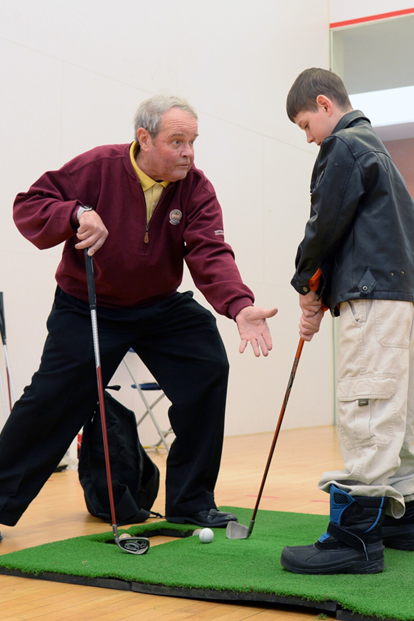Jim Tobin, Patriot Golf Course instructor, works with Joshua St. Pierre on his golf swing during the Health and Fitness Expo at the Fitness and Sports Center, March 25. The Fitness Center hosted various representatives from on- and off-base who provide attendee's health and fitness resources, as well as products and services to enhance wellness. (U.S. Air Force photo by Linda LaBonte Britt)