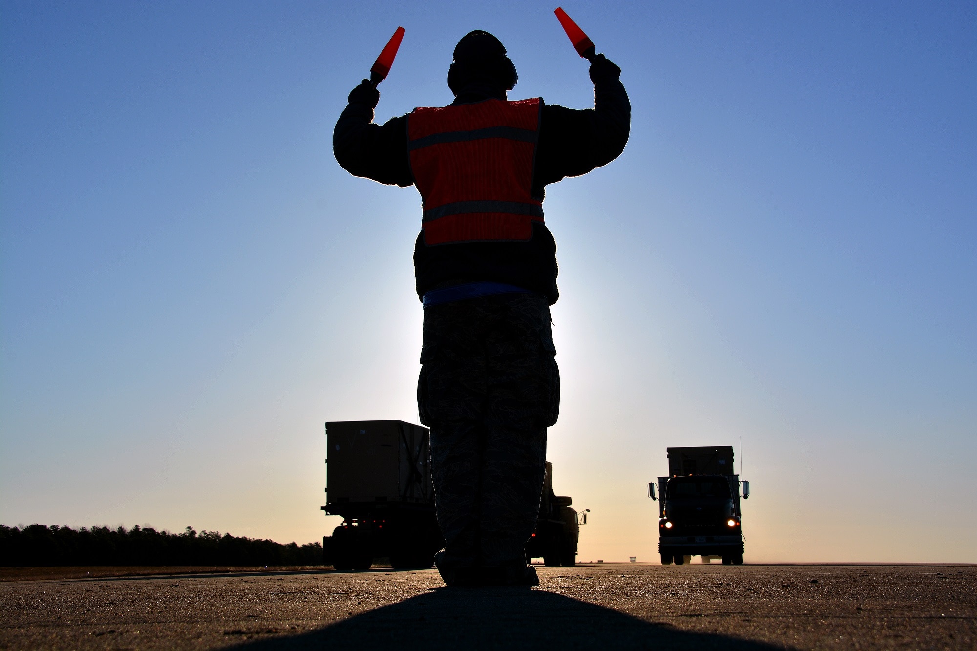 Senior Airman Anthony Clark, 570th Global Mobility Squadron, marshals in a flatbed truck that was used to simulate a C-17 Globemaster III aircraft, March 12, 2015, during Exercise EAGLE FLAG 15-2, at Joint Base McGuire-Dix-Lakehurst, New Jersey. The weeklong, joint-service exercise focused on providing humanitarian aid and disaster relief to fictional refugee camps in the West Africa region. (U.S. Air Force photo by Senior Airman Charles Rivezzo)