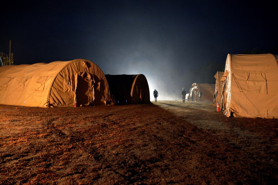 Airmen from the 570th Contingency Response Group walk through a campsite, March 11, 2015, during Exercise EAGLE FLAG 15-2, at Joint Base McGuire-Dix-Lakehurst, New Jersey. EF is a U.S. Air Force Expeditionary Center exercise used to evaluate mobility operations and expeditionary combat support. (U.S. Air Force photo Senior Airman Charles Rivezzo)