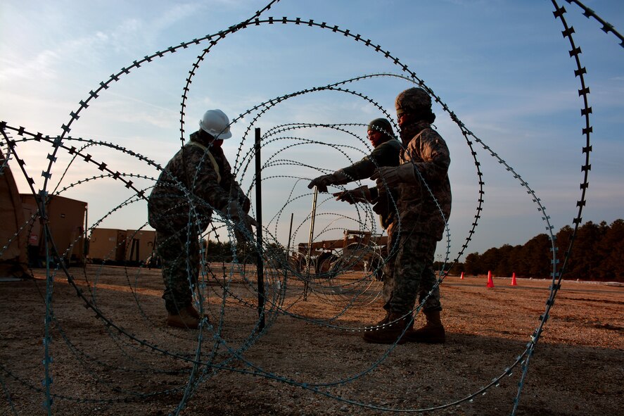 U.S. Army Soldiers from the 688th Rapid Port Opening Element, based out of Fort Eustis, Virginia, setup Constantine wire around a forward operating base, March 10, 2015, during Exercise EAGLE FLAG 15-2, at Joint Base McGuire-Dix-Lakehurst, New Jersey. Exercise EF is a U.S. Air Force Expeditionary Center exercise used to execute and evaluate mobility operations and expeditionary combat support. (U.S. Air Force photo Senior Airman Charles Rivezzo)