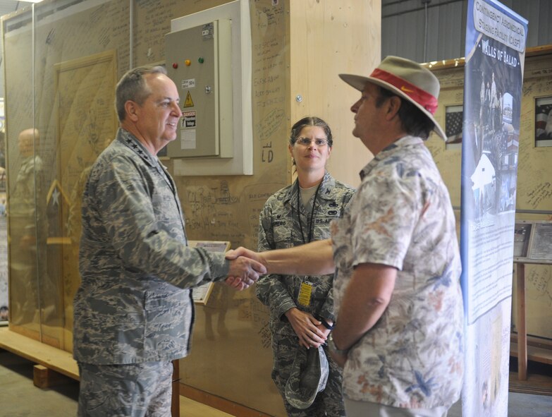Air Force Chief of Staff Gen. Mark A. Welsh III shakes hands with Tommy Bledsoe, 309th Aerospace Maintenance and Regeneration Group business affairs representative while Col. Margaret Romero, 309th AMARG commander looks on at the Walls of Balad exhibit at Davis-Monthan Air Force Base, Ariz., March 25, 2015. The Walls of Balad are signed  by thousands of patients, service members and visitors of Joint Base Balad hospital, Iraq. (U.S. Air Force photo by Cheyenne Morigeau/released)