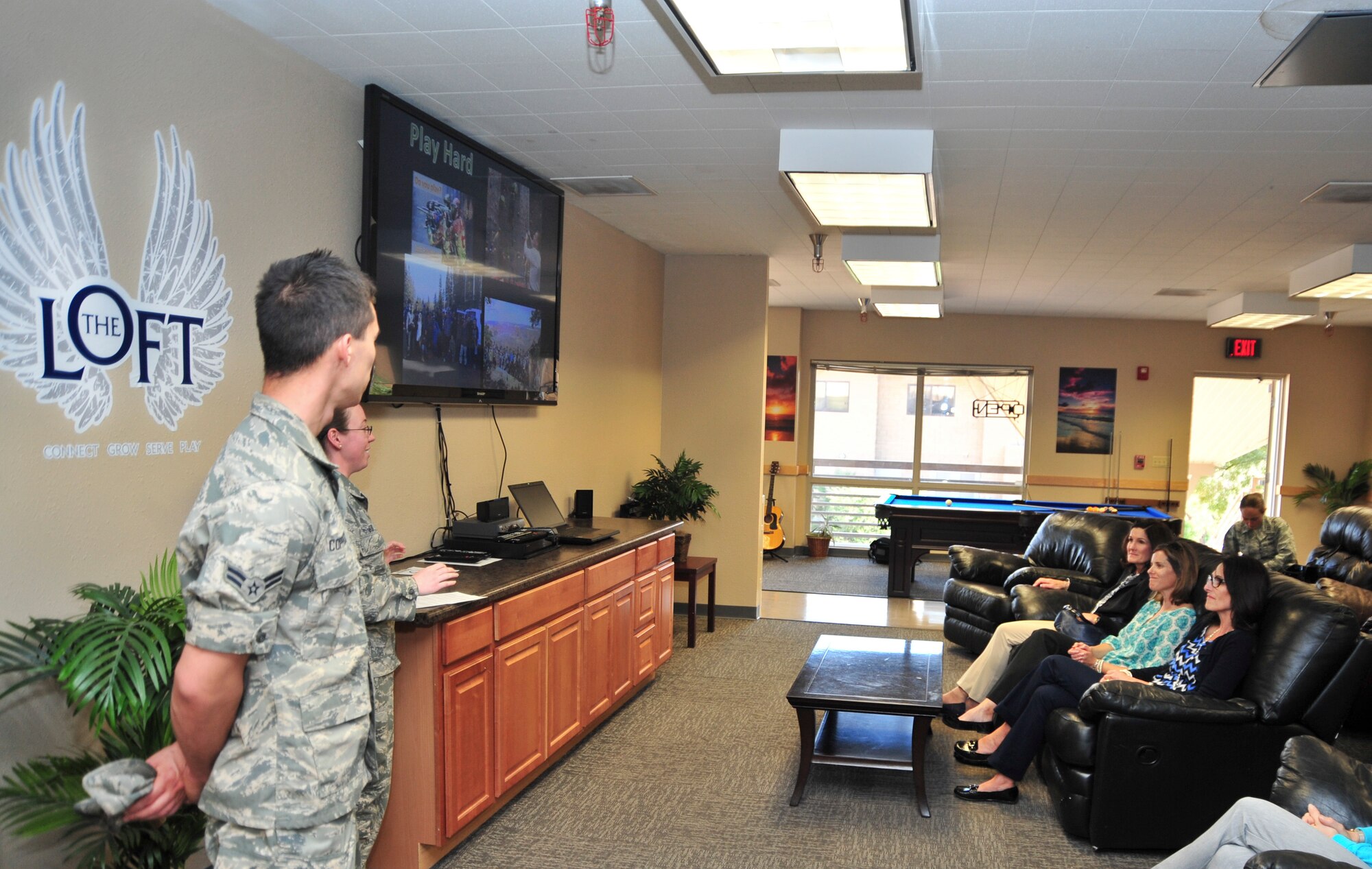 Betty Welsh, spouse of Chief of Staff of the Air Force Gen. Mark A. Welsh III, Kari Meger, wife of 355th FW Commander James Meger, and Kristan Nowland, wife of 12th Air Force(Air Force?s Southern) Commander Chris Nowland, listen to a briefing about The Loft from Airman 1st Class Cristina Eck, The Loft president, at Davis-Monthan Air Force Base, Ariz., March 25, 2015.  Welsh accompanied her husband to D-M to see the mission first hand, thank Airmen for their continued service and dedication, and discuss challenges and opportunities for Airmen and their families. (U.S. Air Force photo by Airman 1st Class Chris Massey/Released)