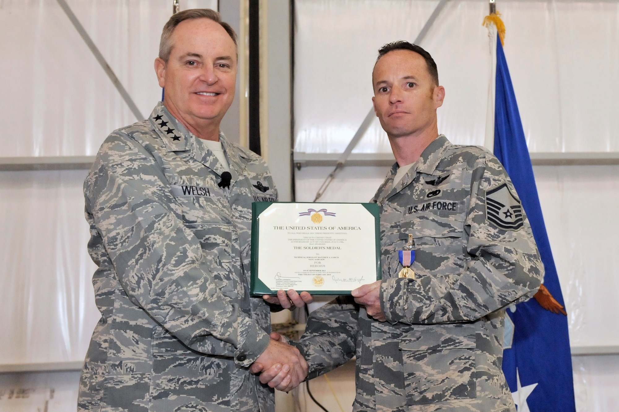 U.S. Air Force Chief of Staff Gen. Mark A. Welsh III and Master Sgt. Matthew Garcia, 55th Rescue Squadron special mission aviator, pose for a photo after a medal presentation at Davis-Monthan Air Force Base, Ariz., March 25, 2015. Welsh presented Garcia with the Soldier?s Medal for his act of heroism that saved the lives of two pilots who were injured after landing their helicopter on an improvised explosive device. (U.S. Air Force photo by Airman 1st Class Chris Drzazgowski/Released)