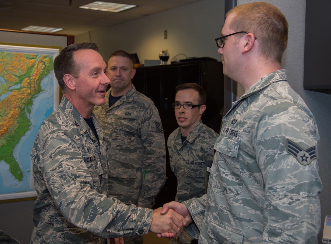 Senior Airman Kyle Alexander, 89th Operational Support Squadron/Operational Weather Squadron weather forecaster, is coined by Col. Brad Hoagland, JBA/11th Wing commander, at the weather flight office on Joint Base Andrews, Md., March 13th, 2015. The 89 OSS/OSW is being recognized for correctly forecasted eight-out-of-eight winter weather system. (U.S. Air Force photo/Airman 1st Class Philip Bryant)