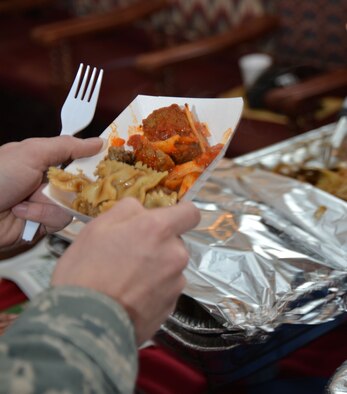 A U.S. Air Force Airman samples meatballs and pasta from one of the vendors at the food show and customer appreciation event March 25, 2015, on RAF Mildenhall, England. A wide variety of foods were showcased to highlight new items which could potentially be added to the 100th Force Support Squadron Gateway Dining Facility menu based on feedback from customers. (U.S. Air Force photo by Karen Abeyasekere/Released)