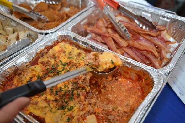 A vendor prepares to serve up ground turkey casserole to Airmen at the 100th Force Support Squadron Gateway Dining Facility customer appreciation event March 25, 2015, on RAF Mildenhall, England. Vendors from the United States, United Kingdom and Germany – many of whom were retired military – showcased new food items to customers by offering free samples, gifts and items of food to take home. The event had an outreach of more than 450 military and civilians and 25 vendors from 13 companies attended.  (U.S. Air Force photo by Karen Abeyasekere/Released)