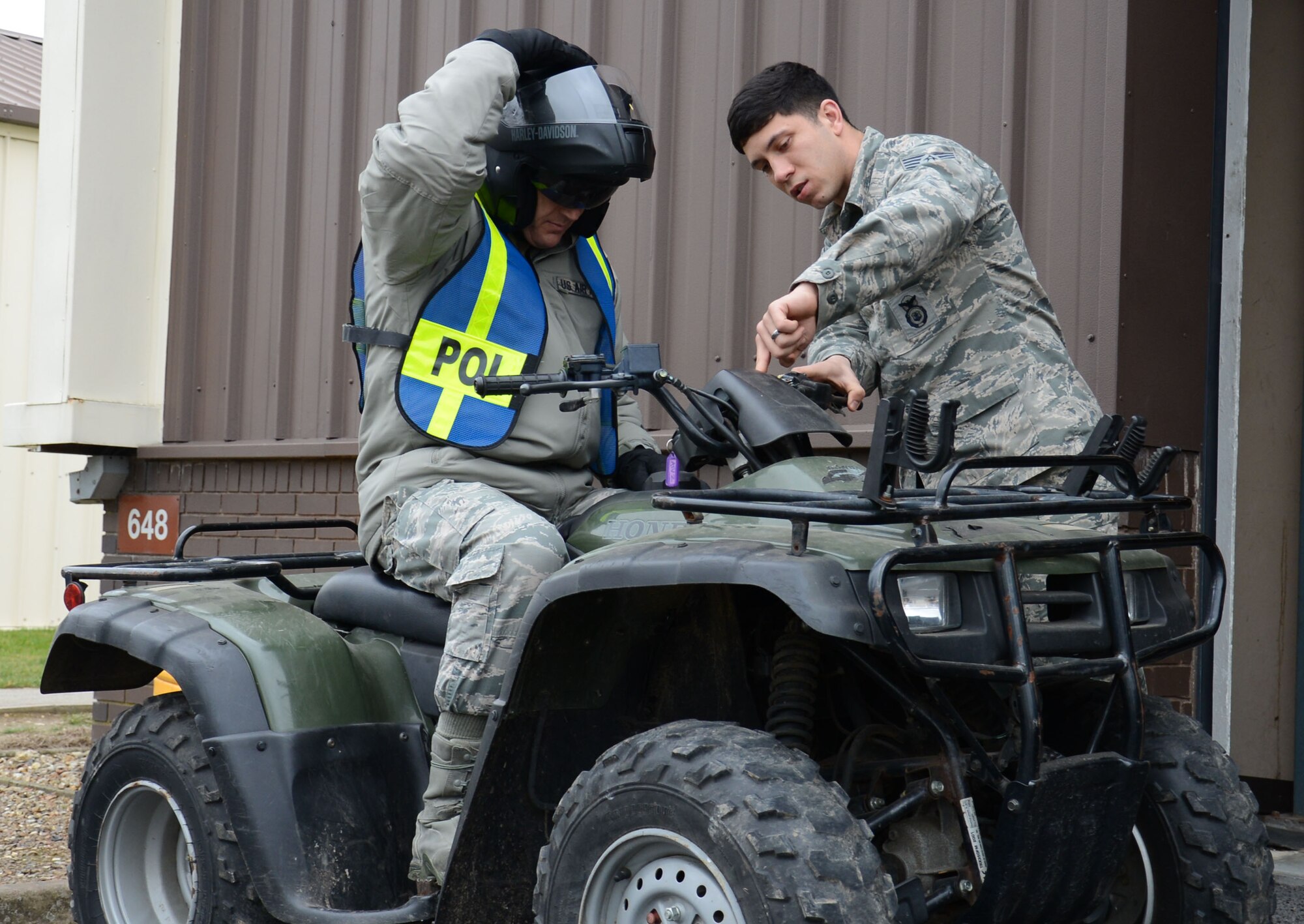 U.S. Air Force Staff Sgt. Samuel Perez, right, 100th Security Forces Squadron NCO in charge of supply from Plainfield, Conn., explains how to control an all-terrain vehicle to U.S. Air Force Chief Master Sgt. Tracy Jones, left, 100th Air Refueling Wing command chief, March 19, 2015, on RAF Mildenhall, England. Jones wore a reflective vest, gloves and a crash helmet for safety, and following the safety brief he spent time in the parking lot to familiarize himself with the ATV. (U.S. Air Force photo by Gina Randall/Released)