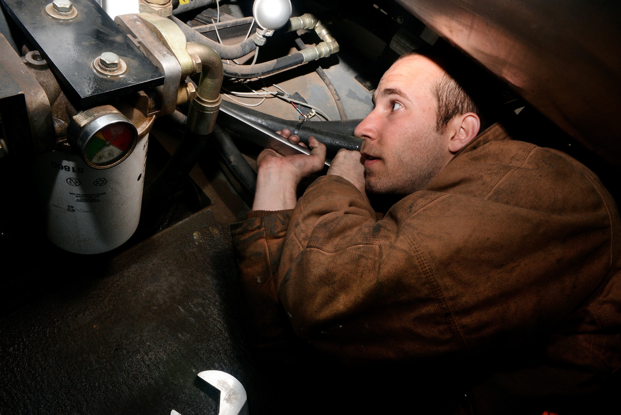ALTUS AIR FORCE BASE, Okla. – U.S. Air Force Senior Airman Ben Dykes, 97th Logistics Readiness Squadron vehicle mechanic, detaches one end of a main de-icing line on a Global De-Icer, March 19, 2015. The hose is approximately 40 feet long, and 1,000 gallons of fluid had to be drained from the vehicle before detaching the hose. The de-icer is the only vehicle on base with the capability to de-ice the planes, making it mission critical during the winter. (U.S. Air Force photo by Airman 1st Class Megan E. Acs/Released)