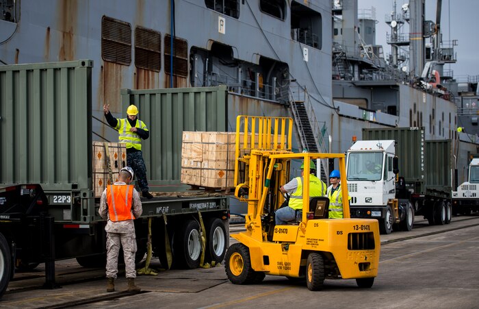 Sailors and Marines with the Navy Munitions Command Unit Charleston load cargo from the USNS Lewis and Clark (T-AKE-1) onto a transport vehicle March, 25, 2015, at Naval Weapons Station Wharf Alpha in Charleston, S.C. The Lewis and Clark is a replenishment naval vessel. In 2012, USNS Lewis and Clark became one of 14 ships that comprise the United States Marine Corps Maritime Prepositioning Program. Prepositioning ships provide quick and efficient movement of military equipment/supplies between operating areas without reliance on other nations' transportation networks. These ships give U.S. regional combatant commanders the assurance that they will have what they need to quickly respond in a crisis - anywhere, anytime. (U.S. Air Force photo/Airman 1st Class Clayton Cupit)