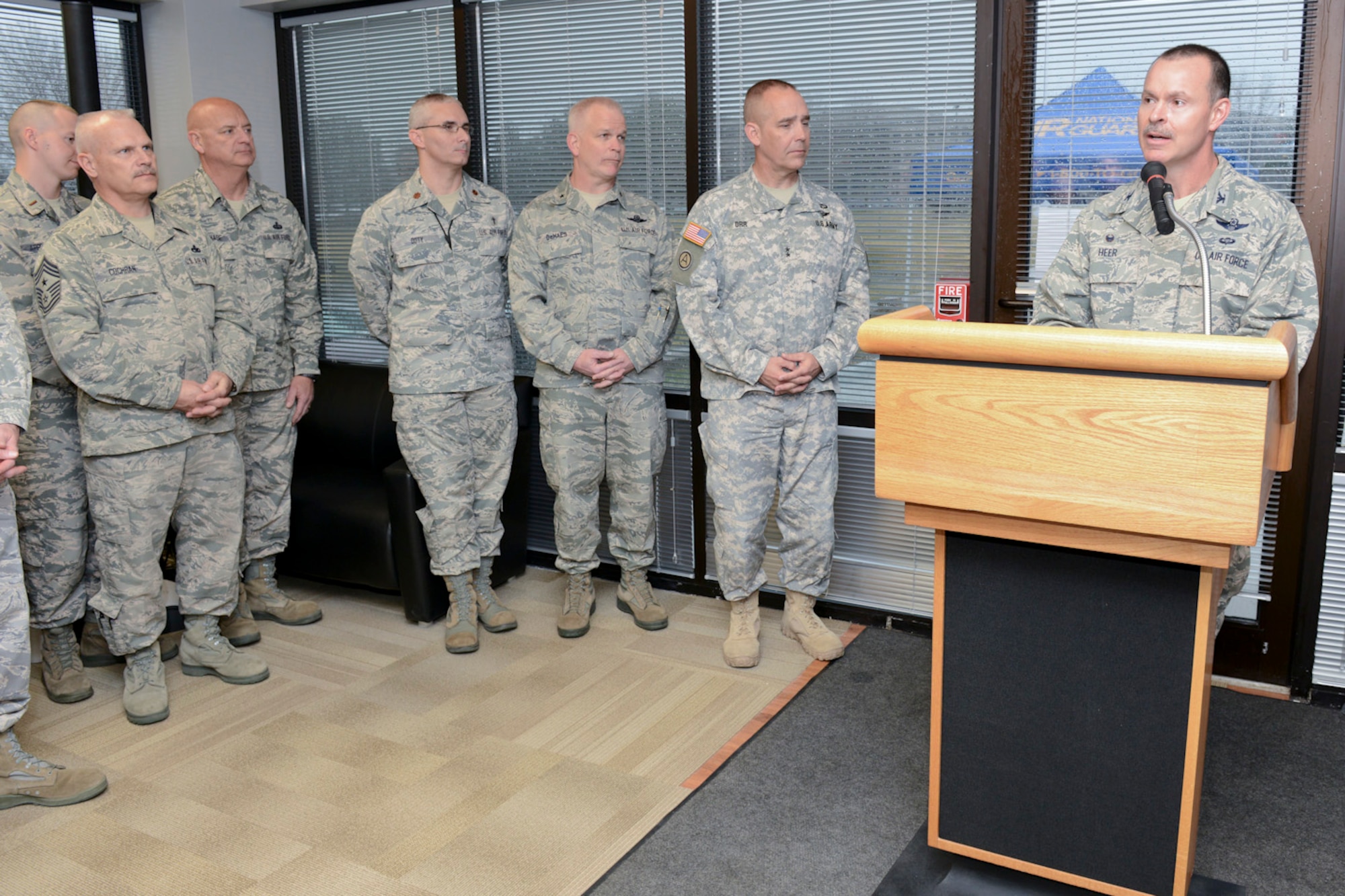 132d Wing (132WG) Commander, Col. Kevin Heer (podium), speaks to members of the Iowa Air and Army National Guard as they celebrate the opening of the 132WG, Des Moines, Iowa off-site Recruiting Operation Center during a ribbon cutting ceremony held at the new Recruiting Operation Center in West Des Moines, Iowa on Tuesday, March 24, 2015.  (U.S. Air National Guard photo by Staff Sgt. Linda K. Burger/Released)