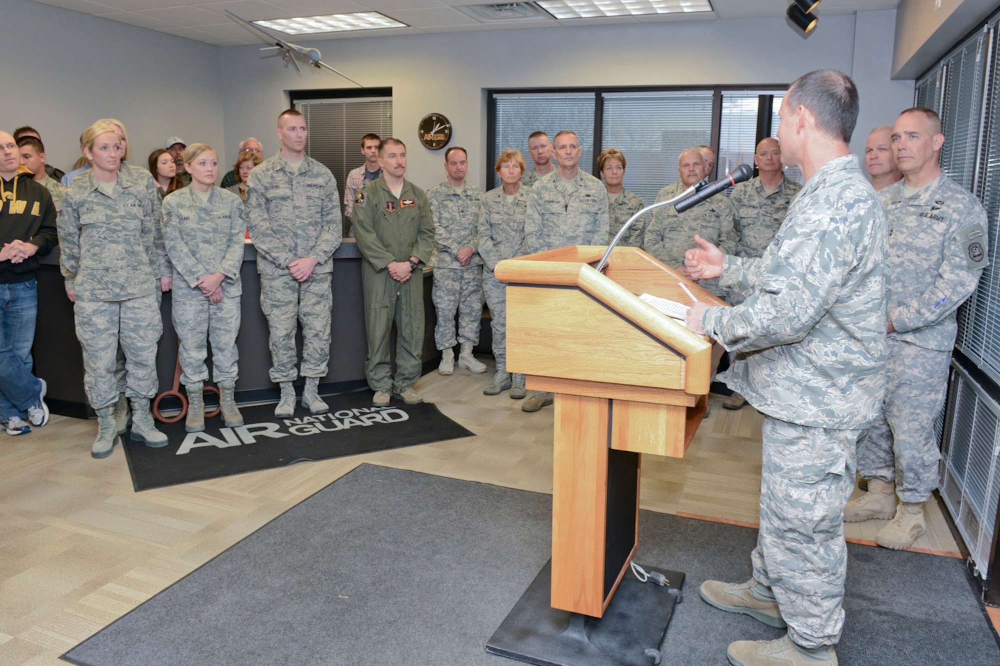 132d Wing (132WG) Commander, Col. Kevin Heer (podium), speaks to members of the Iowa Air and Army National Guard as they celebrate the opening of the 132WG, Des Moines, Iowa off-site Recruiting Operation Center during a ribbon cutting ceremony held at the new Recruiting Operation Center in West Des Moines, Iowa on Tuesday, March 24, 2015.  (U.S. Air National Guard photo by Staff Sgt. Linda K. Burger/Released)