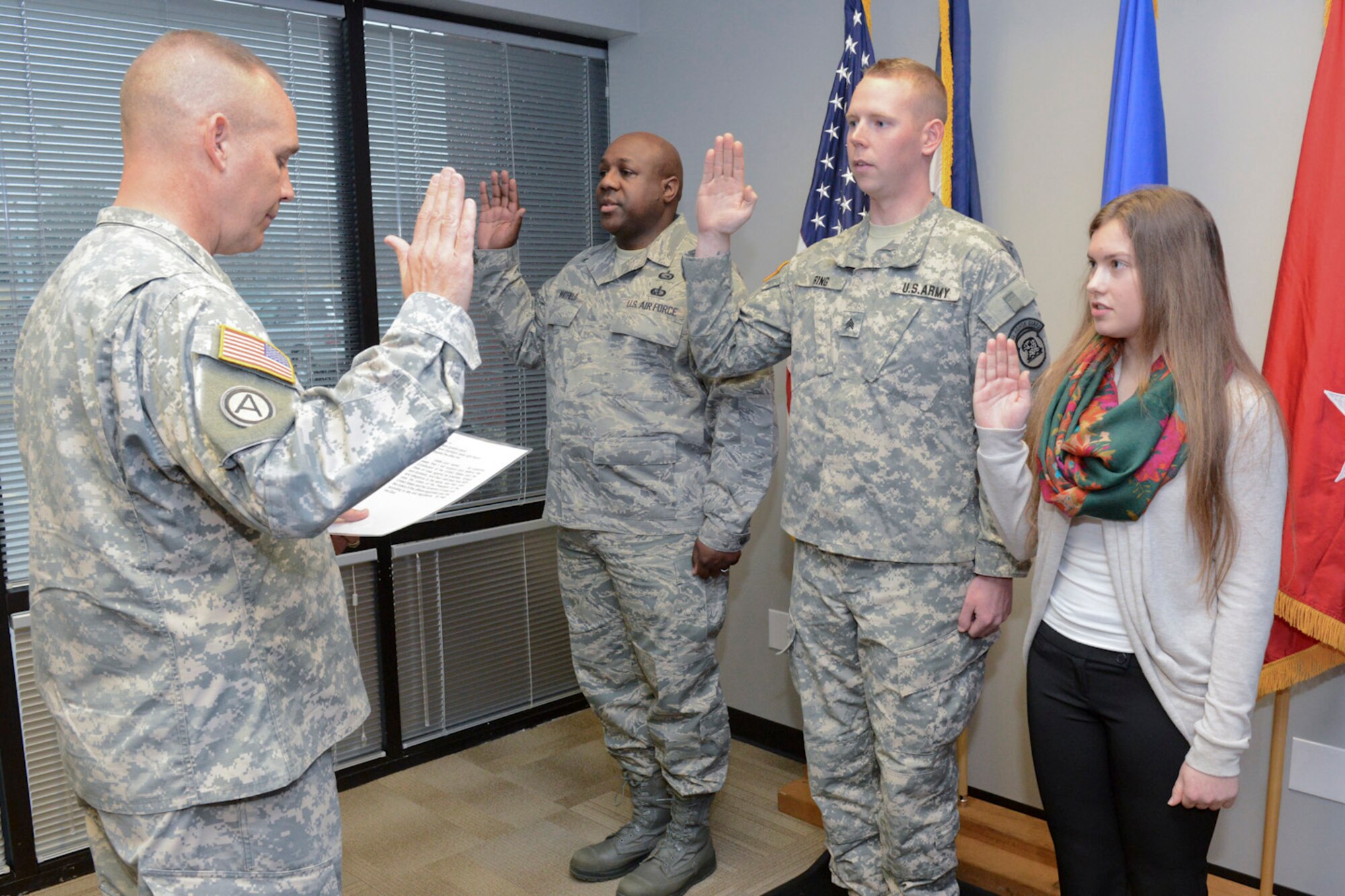 The Adjutant General of the Iowa National Guard, Maj. Gen. Timothy Orr (left) swears in the three newest members of the 132d Wing (132WG) as members of the Iowa Air and Army National Guard celebrate the opening of the 132WG, Des Moines, Iowa off-site Recruiting Operation Center during a ribbon cutting ceremony held at the new Recruiting Operation Center in West Des Moines, Iowa on Tuesday, March 24, 2015.  (U.S. Air National Guard photo by Staff Sgt. Linda K. Burger/Released)