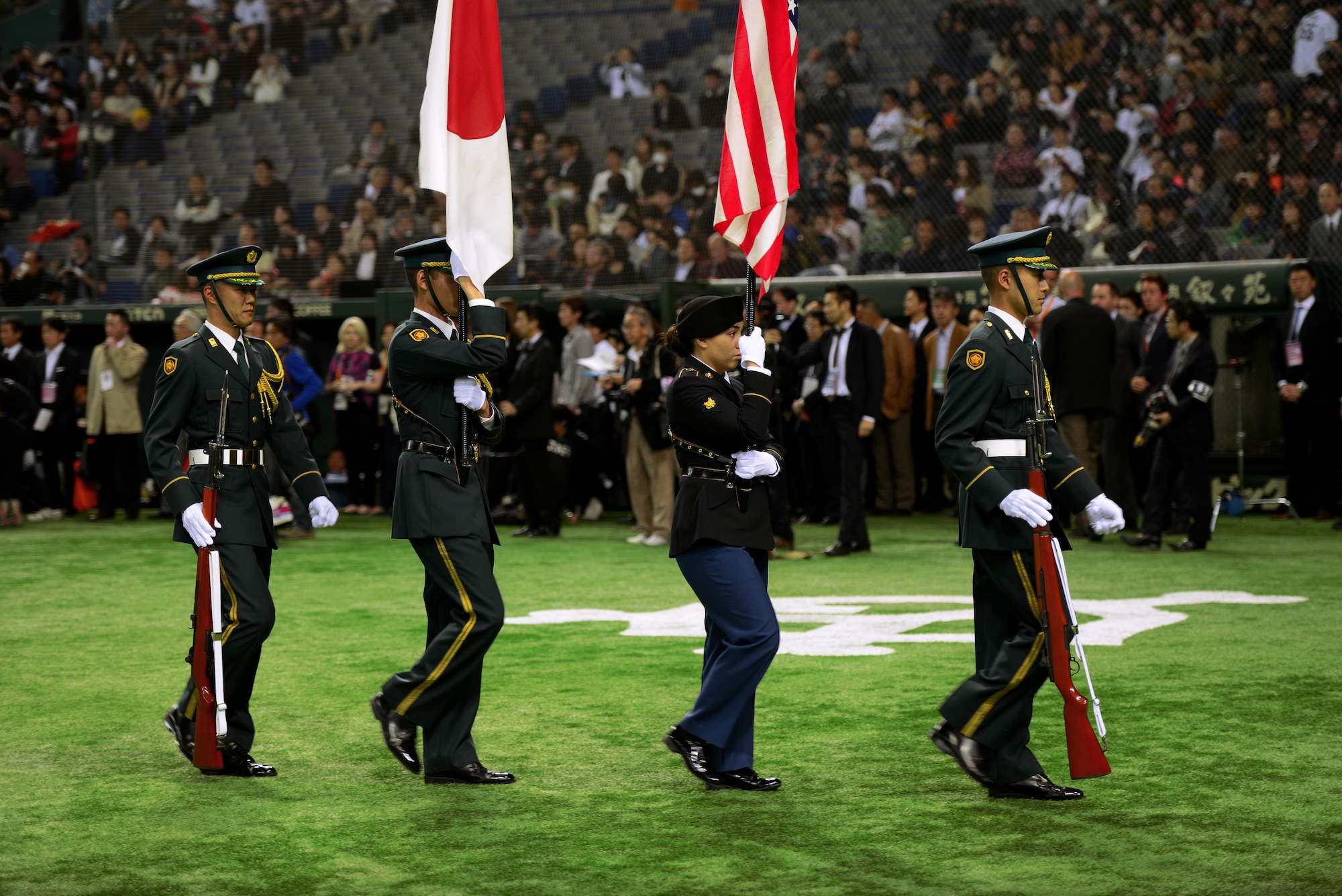 U.S. Army and Japan Ground Self-Defense Force Honor Guard members carry their respective flags during the opening ceremonies at the Tomodachi Charity Baseball Game, March 21, 2015, at the Tokyo Dome, Japan. Middle-school children from throughout Japan participated in the event. (U.S. Air Force photo by Airman 1st Class Delano Scott/Released)