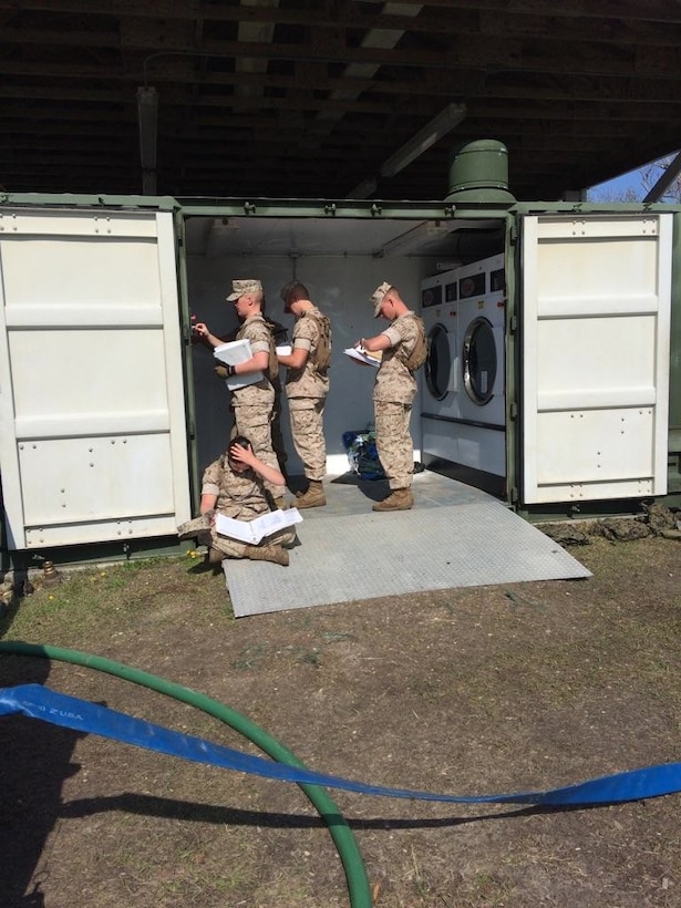 Marines from BWST 5-15 study the characteristics and capabilities of Containerized Batch Laundry operations.