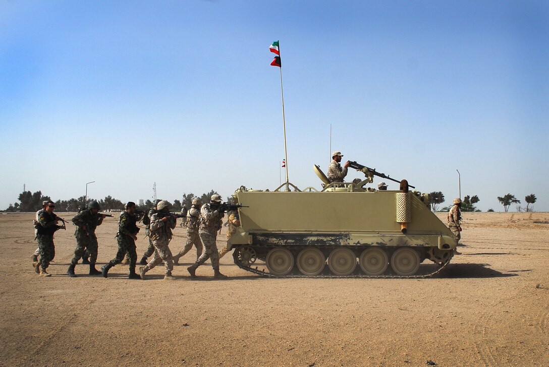 Kuwaiti soldiers trail behind M113 armored personnel carriers while rehearsing for a simulated amphibious assault on Failaka Island, Kuwait, March 24, 2015 during Exercise Eagle Resolve.