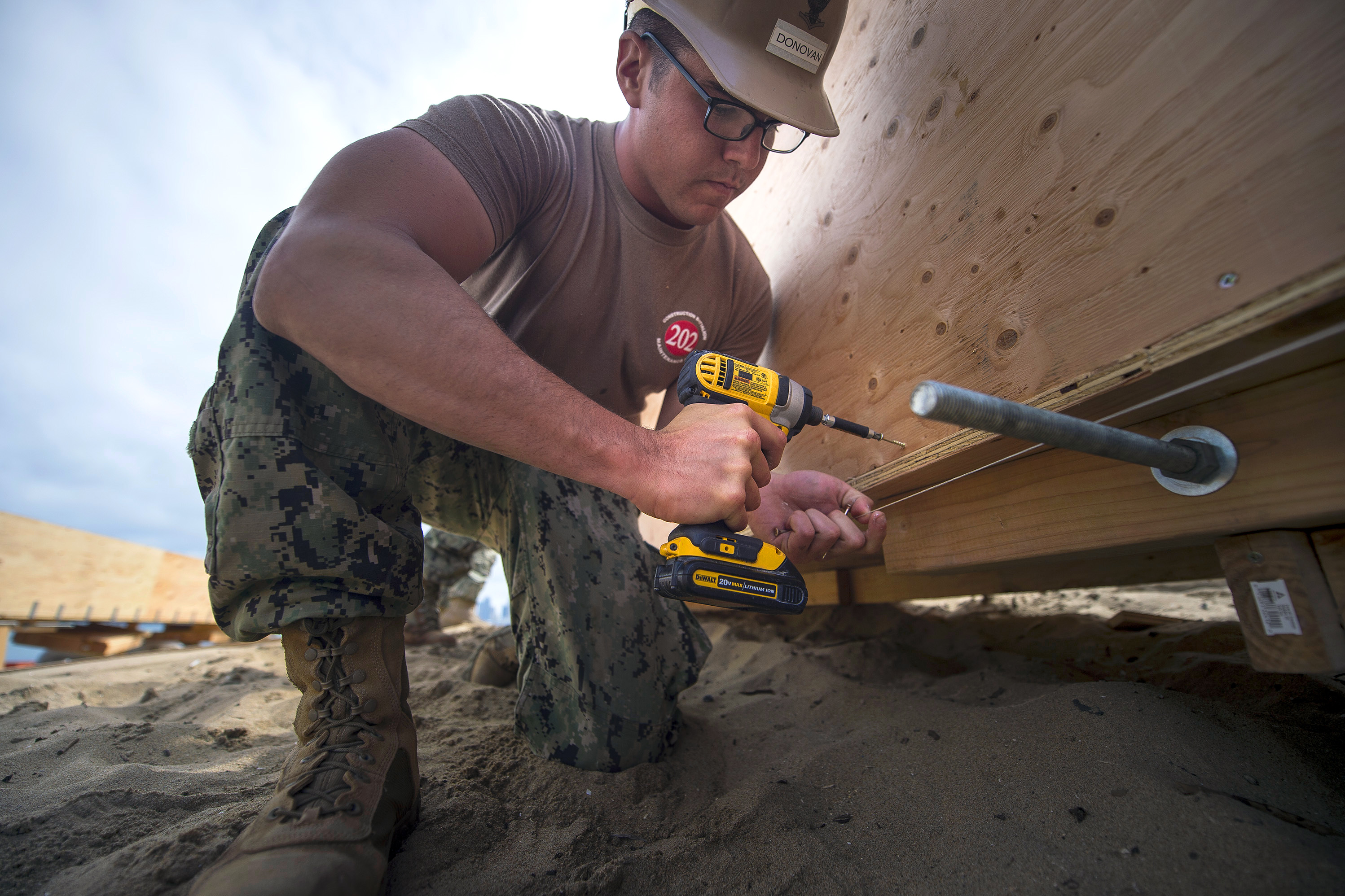 Navy Petty Officer 3rd Class Sean Donovan builds a structure as a team