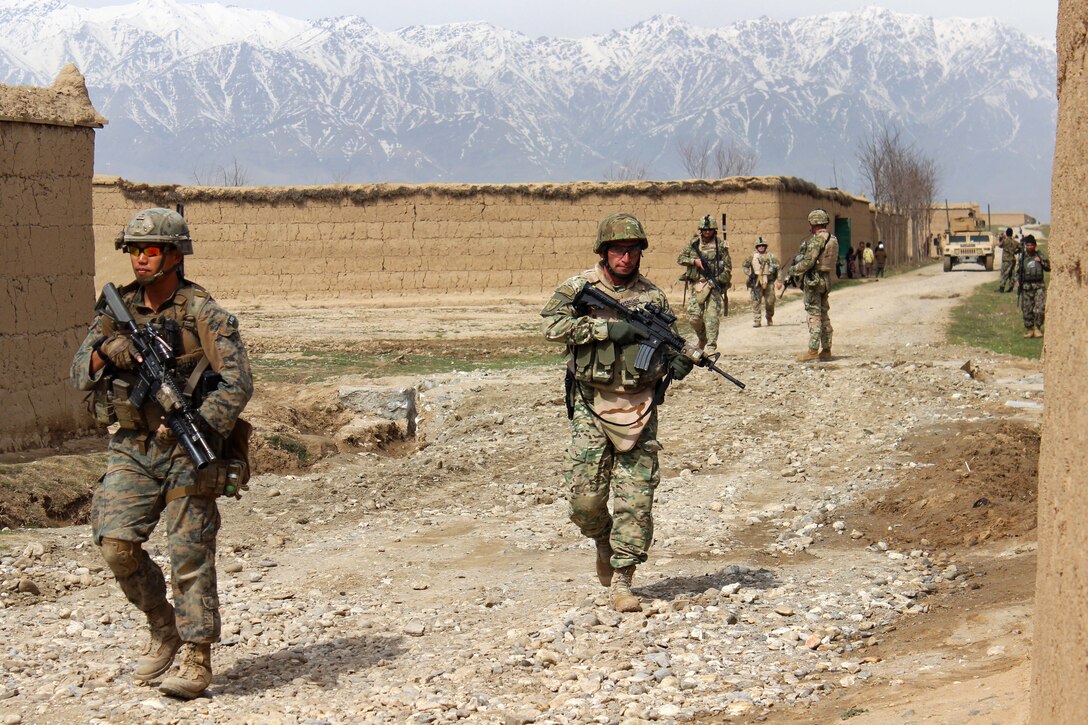 U.S., Georgian and Afghan army soldiers patrol outside of the Qaleh Musa Pain village in Helmand province, Afghanistan, March 12, 2015. The U.S. troops are assigned to U.S. Forces Afghanistan, Task Force Solid. The mission was to attend an opening ceremony for repaired culverts in the village.