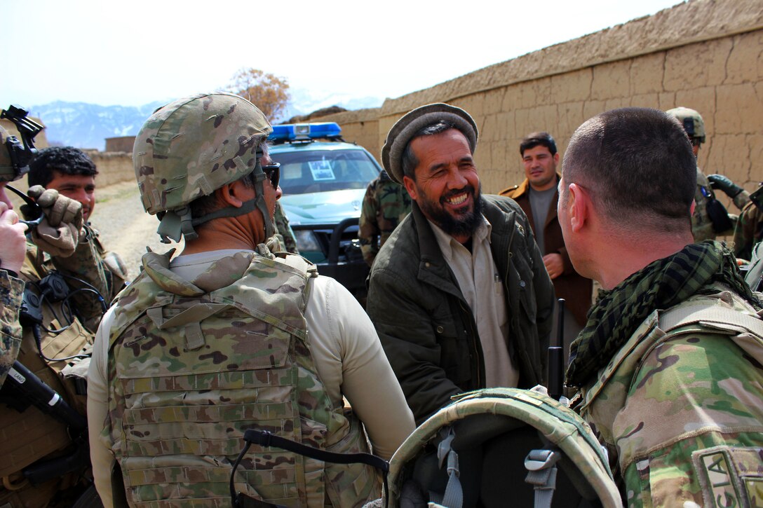 U.S., Georgian and Afghan army soldiers talk with local villagers after a patrol outside of the Qaleh Musa Pain village in Helmand province, Afghanistan, March 12, 2015. 