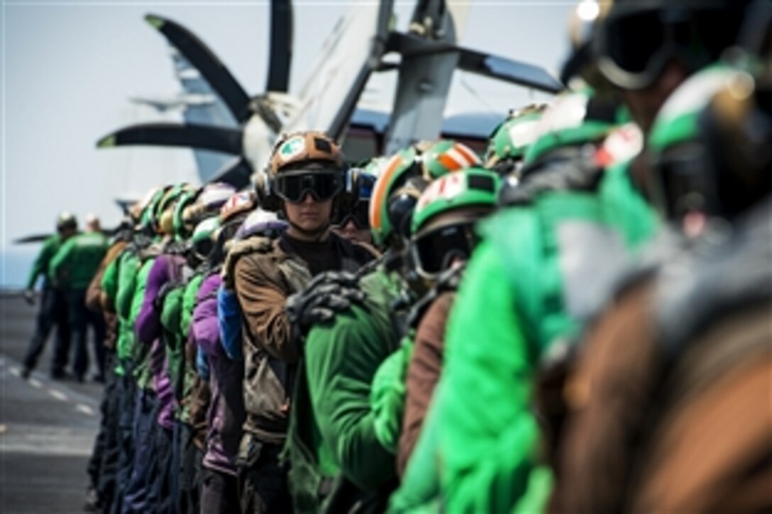 U.S. sailors line up before raising the barricade during a flight deck drill aboard the aircraft carrier USS Carl Vinson in the Persian Gulf, March 21, 2015. The Carl Vinson is deployed in the U.S. 5th Fleet area of responsibility supporting Operation Inherent Resolve.