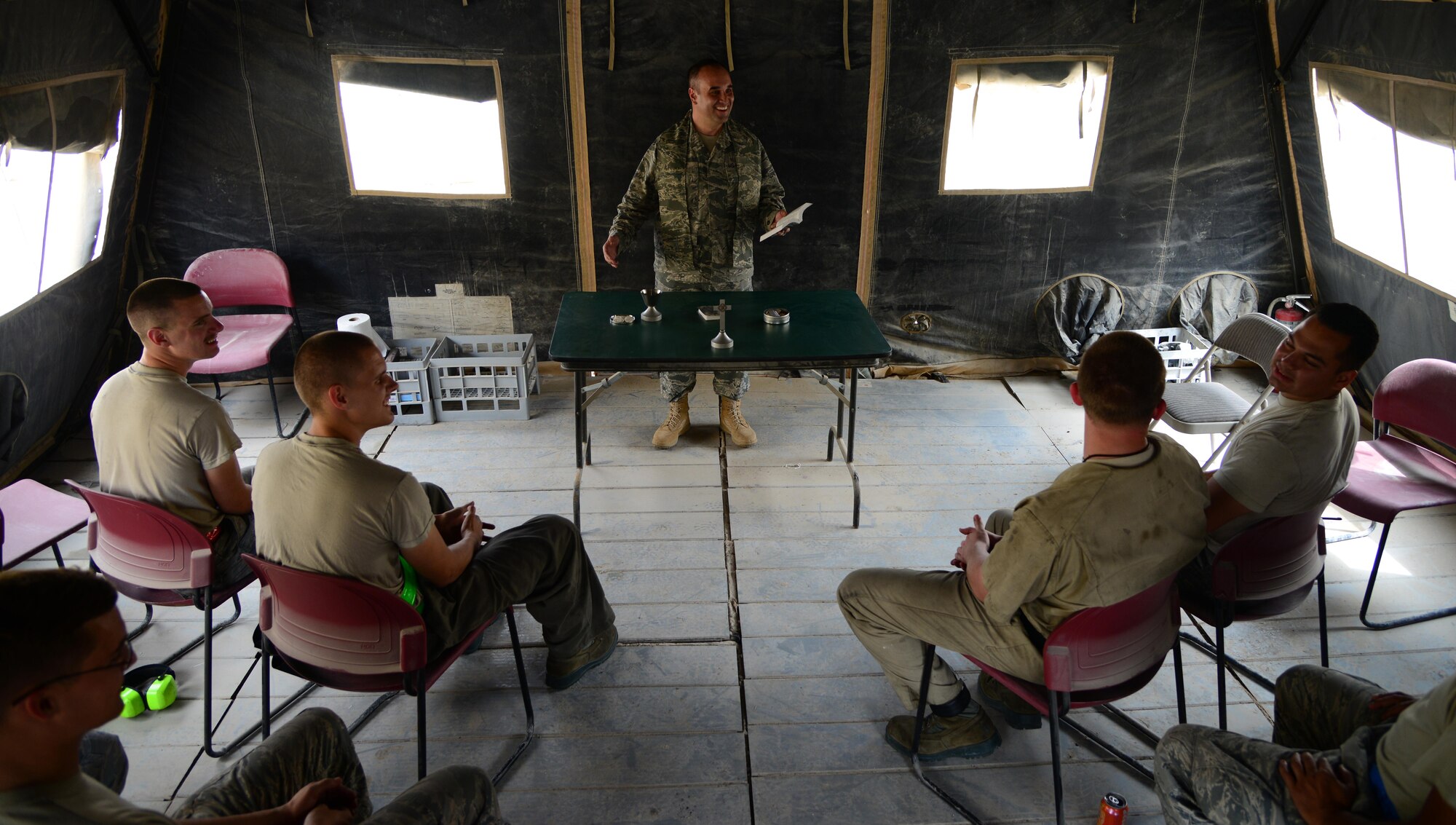 U.S. Air Force Capt. James Henry, center, 379th Air Expeditionary Wing chaplain, provides a worship service for Airmen from the 379th Expeditionary Maintenance Group at the flightline chapel, March 27, 2015, at Al Udeid Air Base, Qatar. Henry is the chaplain for the 379th EMXG and knows how difficult it is for maintenance Airmen to break away from the flightline to attend worship services, so he brings the services to them. (U.S. Air Force photo by Senior Airman Kia Atkins)
