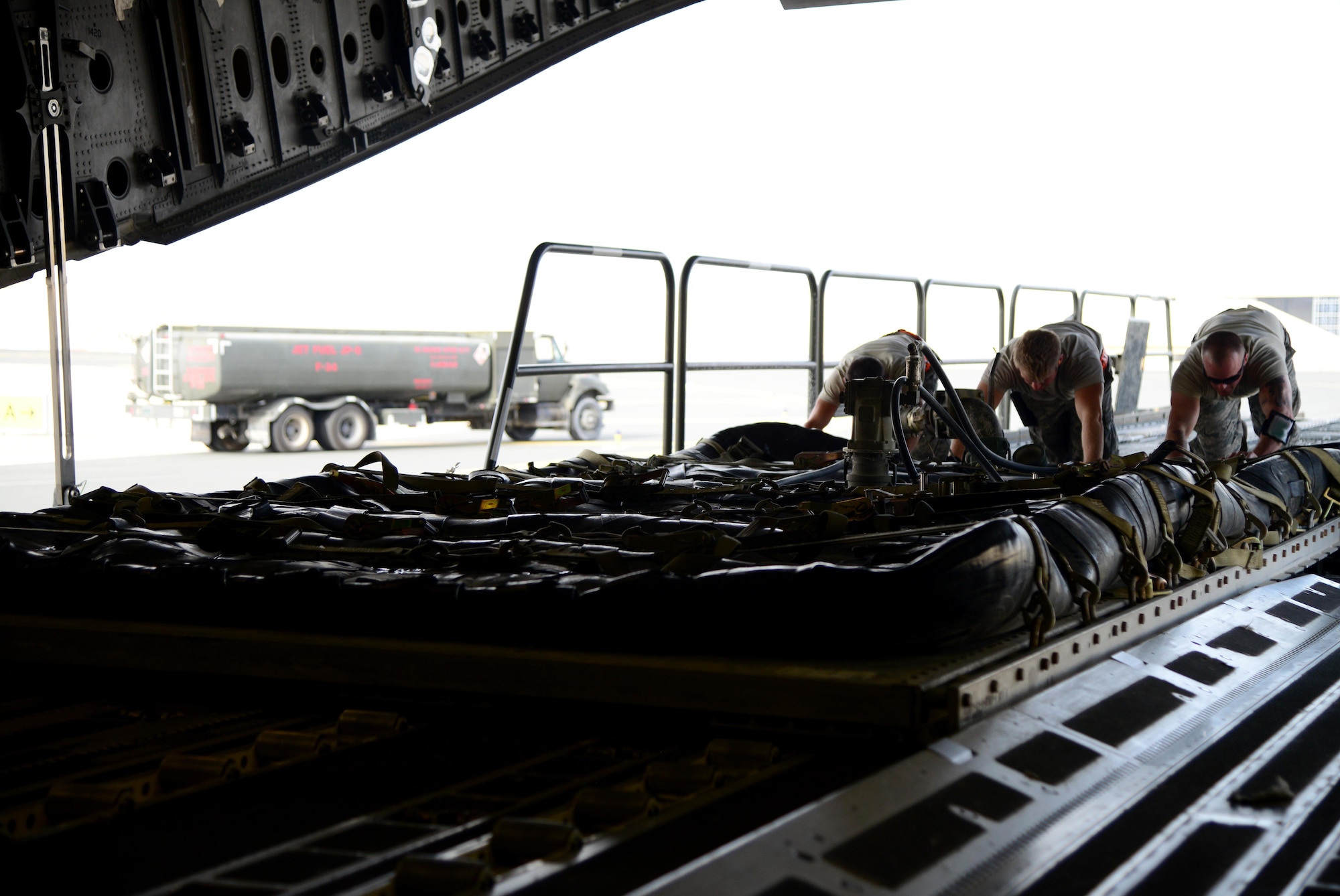 Airmen from the 8th Expeditionary Air Mobility Squadron load fuel bladders onto a C-17 Globemaster, March 23, 2015, at Al Udeid Air Base, Qatar. Whether it’s ammo, vehicles, fuel bladders or war readiness materials, if any type of cargo is needed, Airmen from the 8th Expeditionary Air Mobility Squadron air freight ramp services section, or “Port Dawgs,” get it loaded so it can be taken where it needs to go. (U.S. Air Force photo by Senior Airman Kia Atkins)