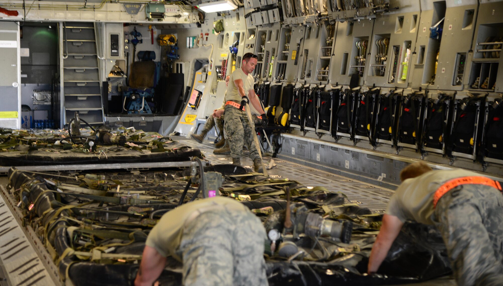 Airmen from the 8th Expeditionary Air Mobility Squadron load fuel bladders onto a C-17 Globemaster, March 23, 2015, at Al Udeid Air Base, Qatar. These Airmen from the 8th EAMS air freight ramp services section are responsible for uploading and downloading cargo and providing fleet services ensuring mobile combat agile support anywhere in the area or responsibility. (U.S. Air Force photo by Senior Airman Kia Atkins)