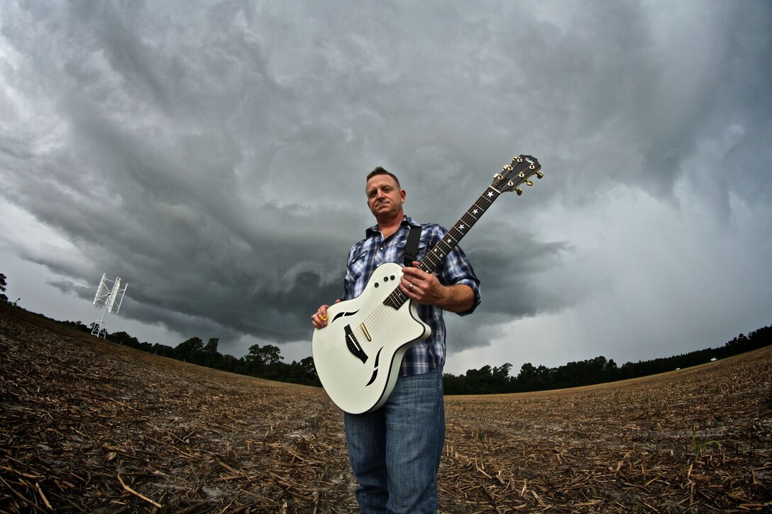 Mike Corrado, a country music singer/song writer stands in a field for photos to promote his music. Corrado is also a lieutenant colnoel is the Marine Corps currently serving as the Deputy Assistant Chief of Staff G-3, 4th Marine Division, Marine Forces Reserve.   