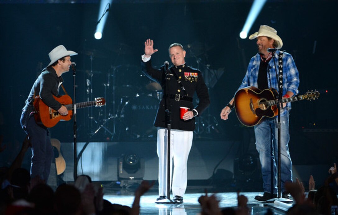 Singer/song writer Scotty Emerick (Left), Lt. Col. Mike Corrado (Middle) Deputy Assistant Chief of Staff G-3, 4th Marine Division  and singer/song writer Toby Keith (Right) stand on stage during ACM Presents: An All-Star Salute To The Troops at the MGM Grand Garden Arena on April 7, 2014 in Las Vegas, Nevada.
