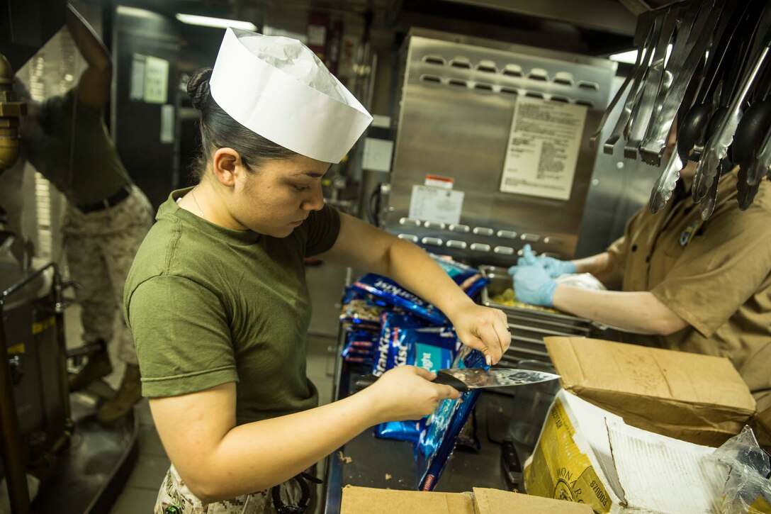U.S. Marine Lance Cpl. Cristina Ngiraklang prepares a tuna-fish casserole for more than 700 Marines and Sailors aboard the USS Rushmore (LSD 47) during Composite Training Unit Exercise (COMPTUEX) off the coast of San Diego March 22, 2015. Ngiraklang is a food service specialist with Combat Logistics Battalion 15, 15th Marine Expeditionary Unit. The food service specialist Marines work long hours to ensure the Marines and Sailors are fed daily. (U.S. Marine Corps photo by Sgt. Emmanuel Ramos/Released)