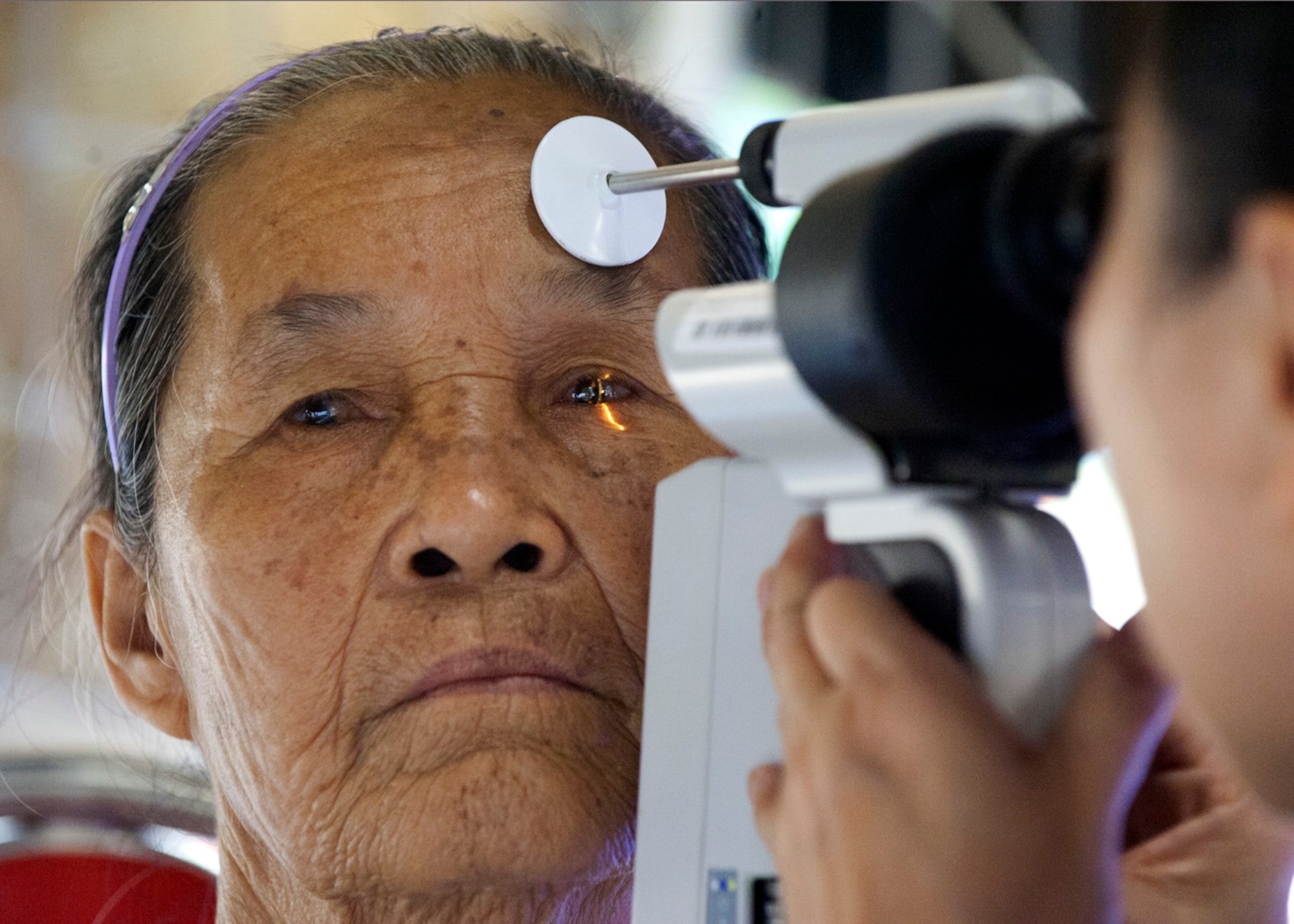 Lt. Col. Thuy Tran conducts an eye exam during an Operation Pacific Angel 15-3 health service outreach event March 23, 2015, at Dung Quat Culture-Sports Center, in Quang Ngai Province, Vietnam. This is the eighth year PACANGEL has worked with regional militaries to prepare and address humanitarian crises, which has helped improved life for tens of thousands of people. Tran is the 142nd Medical Group’s chief of optometry, assigned to the Portland Air National Guard, Ore. (U.S. Air Force photo/Staff Sgt. Tong Duong)