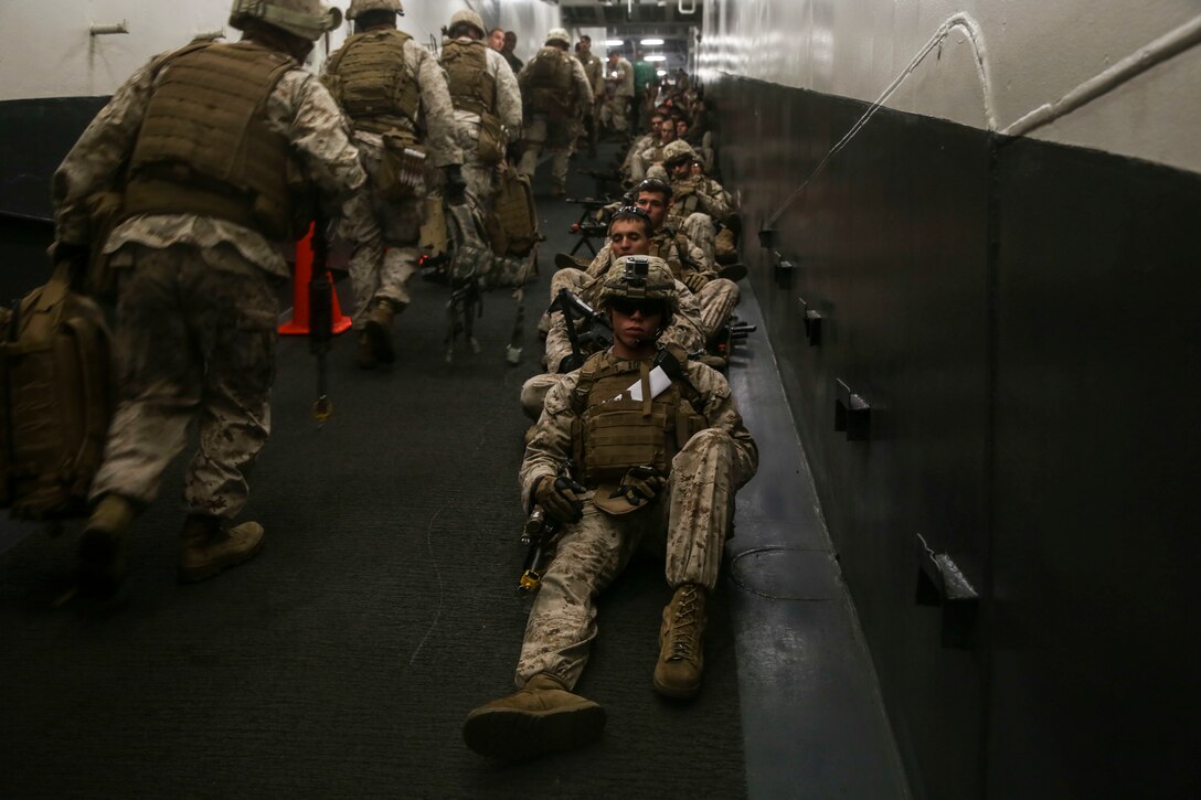U.S. Marines with Lima Company, Battalion Landing Team 3rd Battalion, 1st Marine Regiment, 15th Marine Expeditionary Unit, wait to depart the USS Essex (LHD 2) on a simulated airfield seizure mission during Composite Training Unit Exercise (COMPTUEX) March 22, 2015. These Marines inserted onto San Clemente Island where they practiced clearing and securing combat towns in preparation for the MEU’s upcoming deployment. (U.S. Marine Corps photo by Cpl. Anna Albrecht/Released)