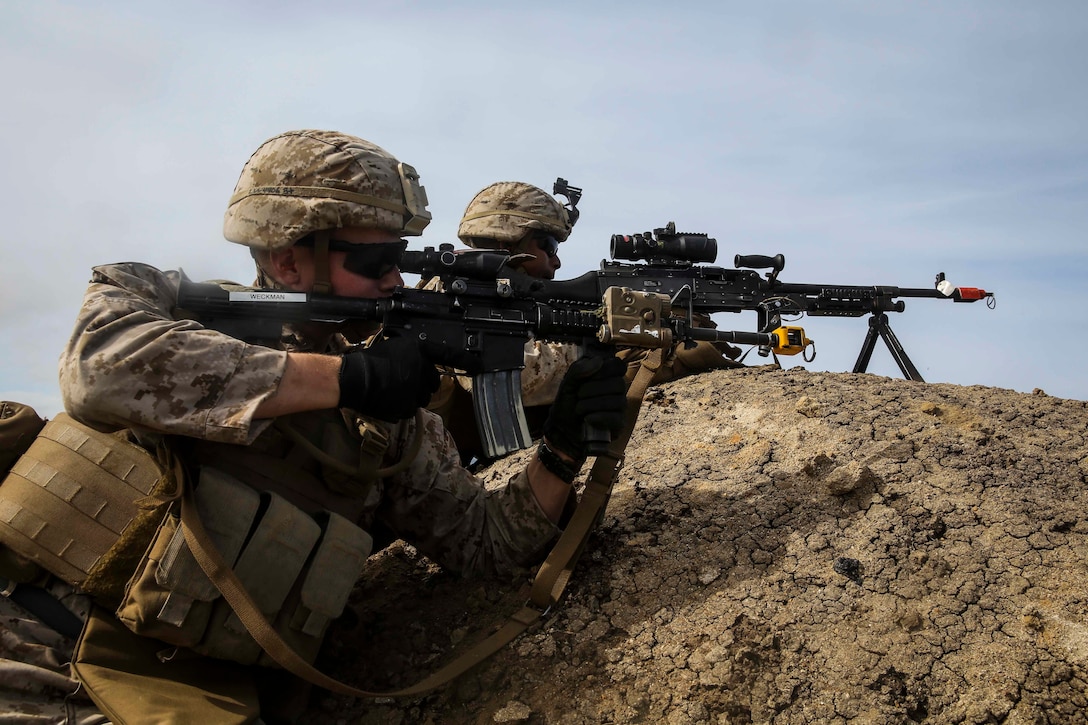 U.S. Marines with Lima Company, Battalion Landing Team 3rd Battalion, 1st Marine Regiment, 15th Marine Expeditionary Unit, provide over-watch on their objective during an airfield seizure mission as part of Composite Training Unit Exercise (COMPTUEX) on San Clemente Island, Calif., March 22, 2015. These Marines inserted onto the island from the USS Essex (LHD 2) to execute a raid and practice their urban combat skills. (U.S. Marine Corps photo by Cpl. Anna Albrecht/Released)