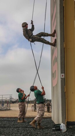 A recruit of Delta Company, 1st Recruit Training Battalion, descends the tower by leaning back and walking straight down during the rappel tower at Marine Corps Recruit Depot San Diego, March 20. The rappel tower consists of a 15-foot fast rope rappel station a 60-foot side wall rappel station, and a 60-foot center hole (hell hole) rappel station.