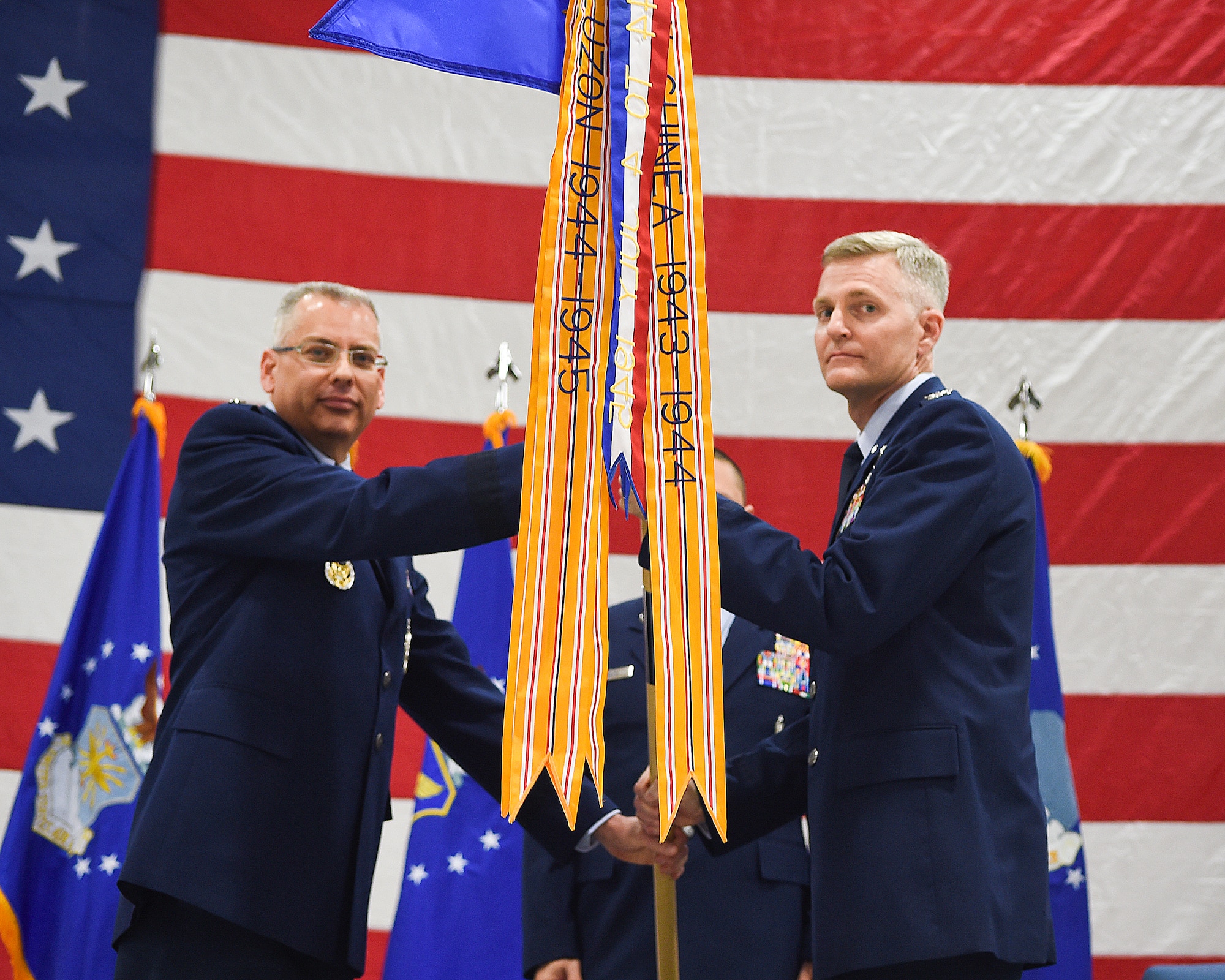 Maj. Gen. Jack Weinstein, Task Force 214 and 20th Air Force commander, presents the guidon of the 582nd Helicopter Group to Col. Dave Smith during the assumption of command ceremony March 27, 2015, on F.E. Warren Air Force Base, Wyo. The new group, comprised of the three helicopter squadrons under 20th AF and the newly established 582nd Operations Support Squadron, was formed to improve mission effectiveness and standardize helicopter operations throughout the 20th AF. (U.S. Air Force photo by R.J. Oriez/Released)