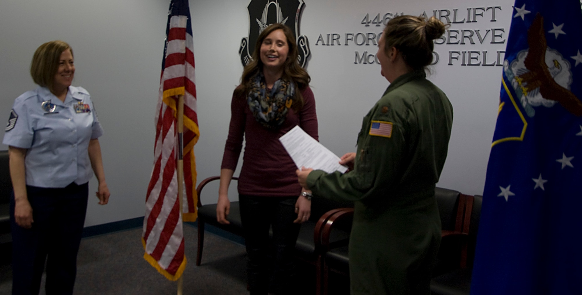 Reily Finnelly, center, is all smiles following her oath of office March 25 at Joint Base Lewis-McChord, Washington.  With the help of Master Sgt. Yvette Larson, left, the 446th Airlift Wing Officer Accessions Recruiter, and Maj. Heather Huot, 313th Airlift Squadron, at McChord Field, Finnelly is entering the Air Force Reserve as a pilot trainee. (U.S. Air Force Reserve photo by Sandra Pishner)