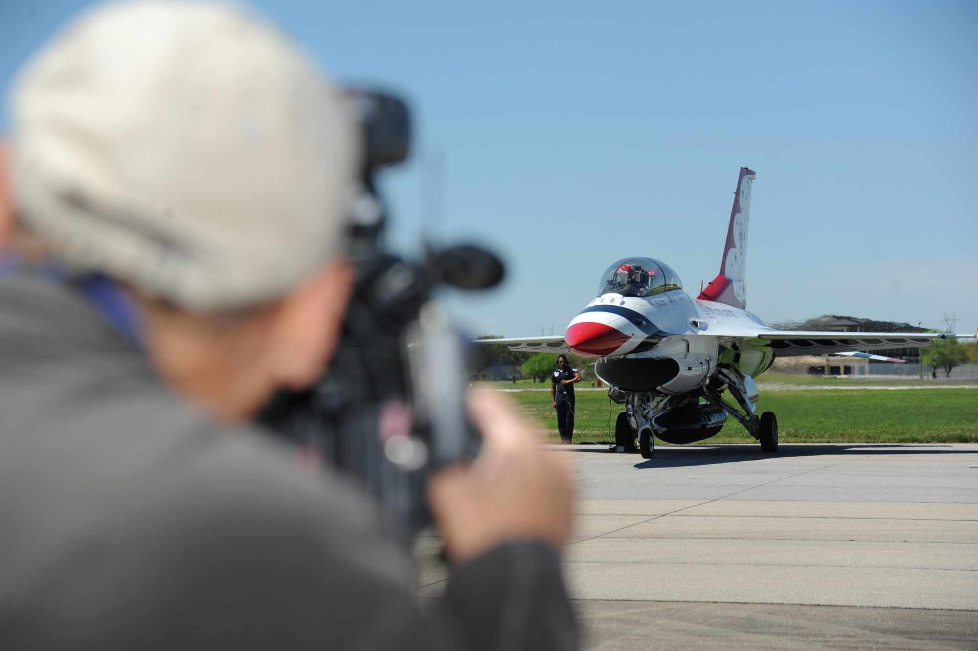 Rodney Billingsby, WLOX camera operator, films Meggan Gray, WLOX anchor, as she sits inside an F-16 Fighting Falcon during a media flight with the U.S. Air Force Thunderbirds March 27, 2015, at Keesler Air Force Base, Miss. The Thunderbirds are headlining Keesler’s 2015 Air Show/Open House to be held March 28-29.  (U.S. Air Force photo by Kemberly Groue)