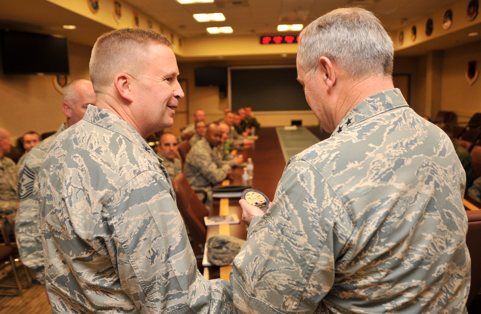 Col. James Cluff, 432nd Wing/432nd Air Expeditionary Wing commander, left, presents Chief of Staff of the Air Force Gen Mark A. Welsh III with the wing’s two million hour coin before a commander’s roundtable discussion during Welsh’s visit to Creech Air Force Base, Nev., March 24, 2015. During the discussion, Welsh addressed changes within the Air Force such as the new enlisted performance report system, force management, and the importance of the ISR mission. (U.S. Air Force photo by Airman 1st Class Christian Clausen/Released)