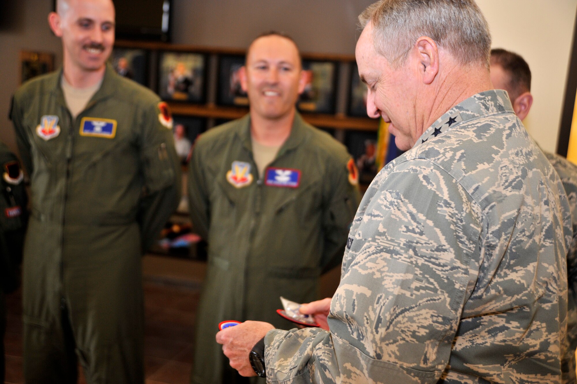 Chief of Staff of the Air Force Gen. Mark A. Welsh III, right, looks at coins and patches presented from the 432nd Wing/432nd Air Expeditionary Wing senior non-commissioned officers during his visit to Creech Air Force Base, Nevada, March 24, 2015. Welsh met with RPA pilots, senior NCOs, and squadron and group commanders of the 432nd Wing and 799th Air Base Group to discuss changes within the Air Force such as the new enlisted performance report system, force management, and the importance of the ISR mission. (U.S. Air Force photo by Airman 1st Class Christian Clausen/Released)