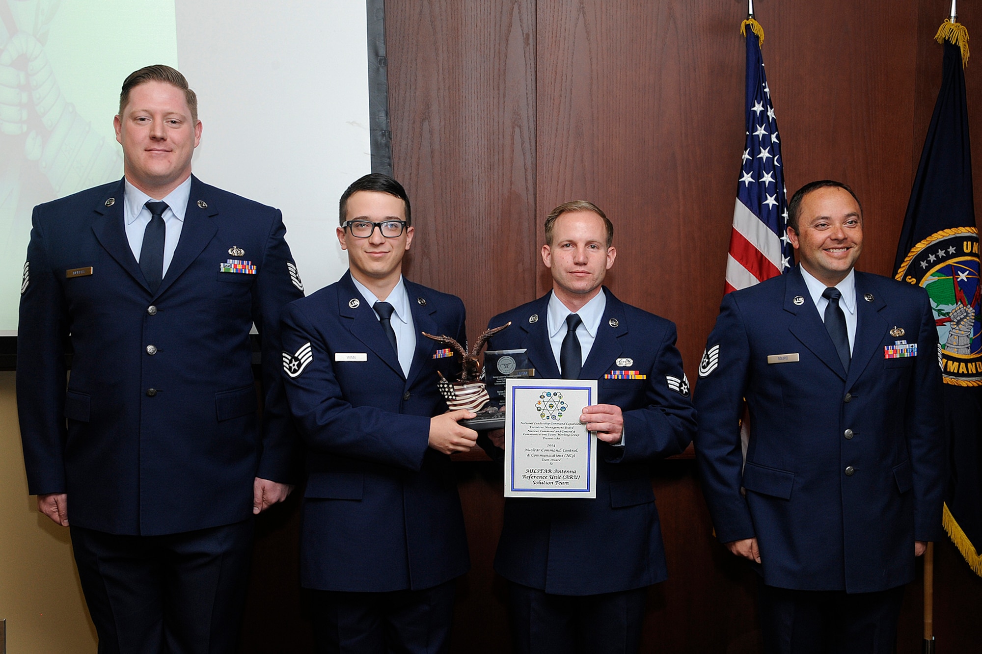 U.S. Air Force Tech. Sgt. Grady Murphy, Staff Sgt. Guy Winn, Senior Amn. Jonathon Smail and Tech. Sgt. Jeremy Gourd from the 223d Space Communication Squadron, MILSTAR Antenna Reference Unit Solution Team receive the 2014 Department of Defense Chief Information Officer Nuclear Command, Control and Communications Team Award during an Integrated Tactical Warning and Attack Assessment stakeholder's meeting, Peterson Air Force Base, Colo., Feb. 24, 2015. U.S. Navy Adm. Cecil D. Haney (not pictured), U.S. Strategic Command commander, hosted the conference and recognized the team's accomplishments in support of the nuclear enterprise by presenting its members with command coins. USSTRATCOM oversees the nation's strategic forces, including bomber, intercontinental ballistic missile and submarine forces, as well as the communication networks and sensors that tie them all together. (Photo courtesy of Duncan Wood, Air Force Space Command)