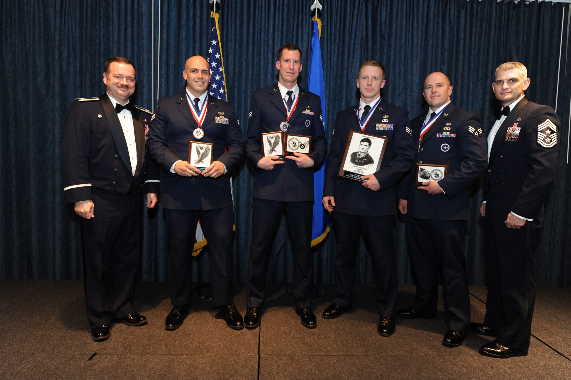 The distinguished graduates from Airman Leadership School Class 15-C pose with Col. Brain McDaniel, 92nd Air Refueling Wing commander, and Chief Master Sgt. Christian Pugh, 92nd ARW command chief, March 26, 2015, at Fairchild Air Force Base, Wash. ALS is a five-week long course that develops Airmen into supervisors and focuses on leadership abilities, profession of arms and effective communication in the workplace. (U.S. Air Force photo/Airman 1st Class Nicolo J. Daniello)