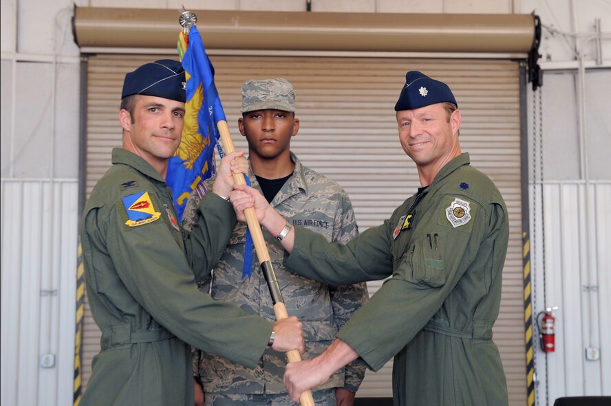 U.S. Air Force Col. Clinton Eichelberger, 355th Operations Group commander, hands the 357th Fighter Squadron guidon to Lt. Col. Joseph Turnham, 357th Fighter Squadron commander, at the 357th FS change of command ceremony at Davis-Monthan Air Force Base, Ariz., March 27, 2015. Turnham is a senior pilot with nearly 2,700 hours in the A-10, including 900 combat hours. (U.S. Air Force photo by Airman 1st Class Chris Drzazgowski/Released) 